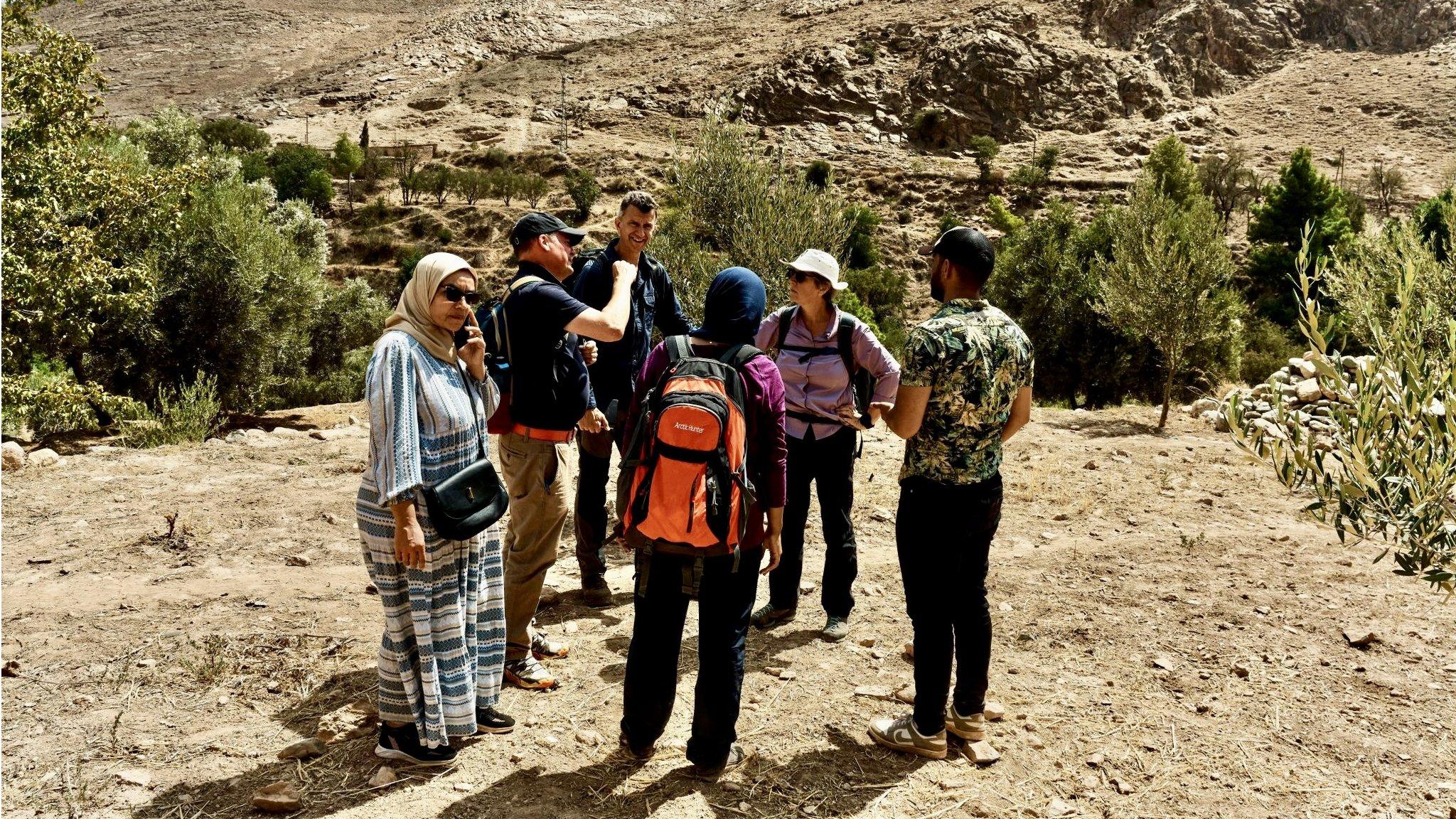 Six people standing on dry earth on the mountain