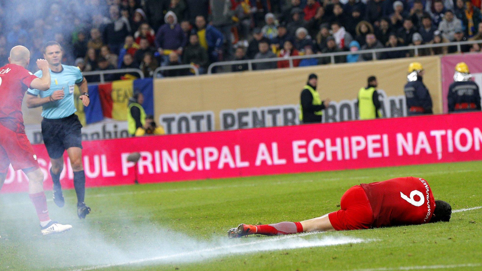 Robert Lewandowski on the floor after flare explodes