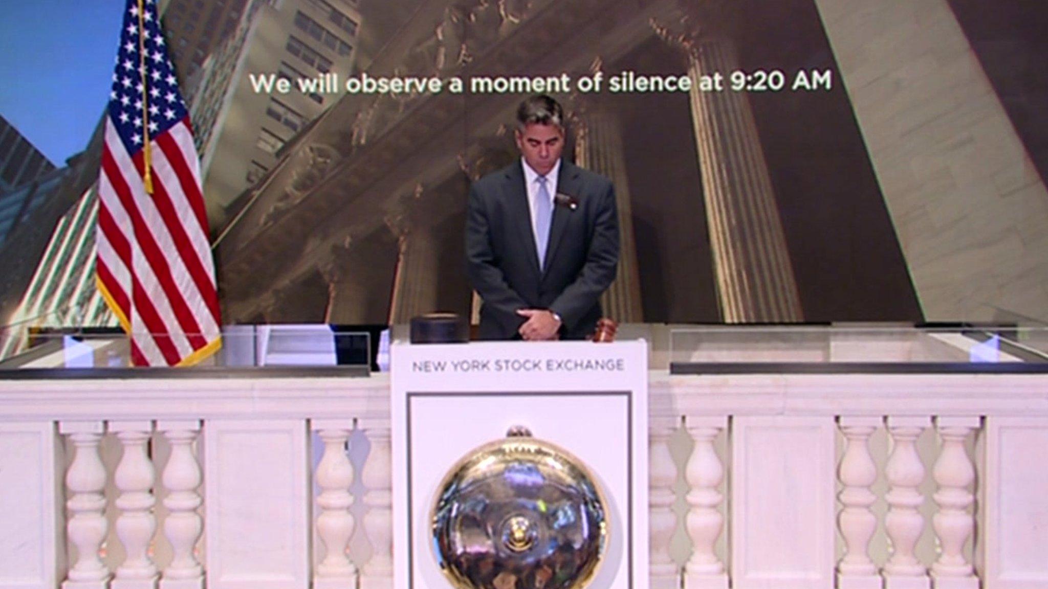 A man bows his head at the New York Stock Exchange.