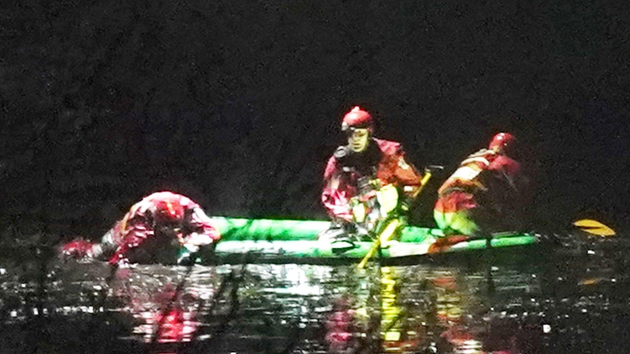 Emergency workers on board a boat on the lake in Babs Mill Park