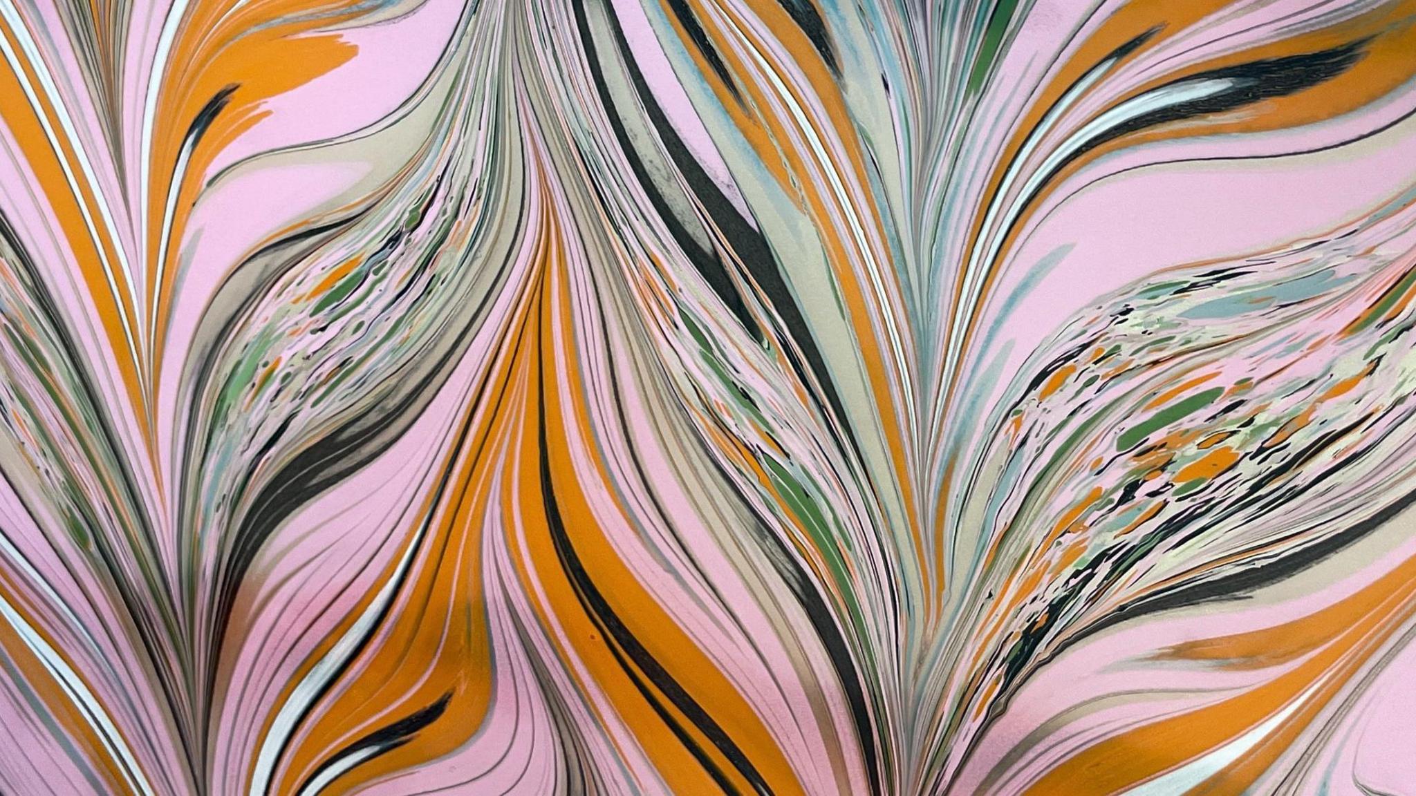 Pink, black, white and orange ink merge together to create a feather-like design.