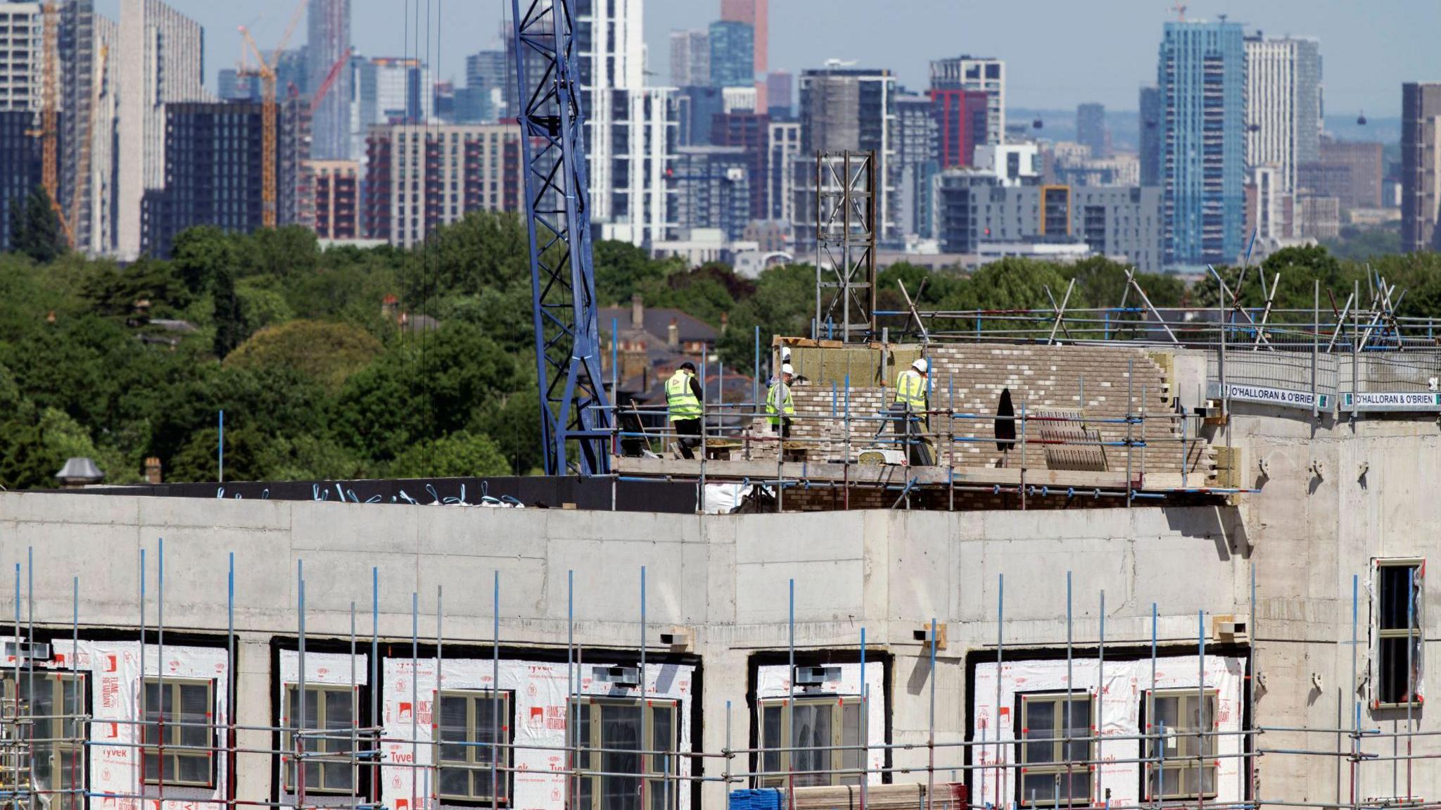 Construction workers on top of a building with scaffolding