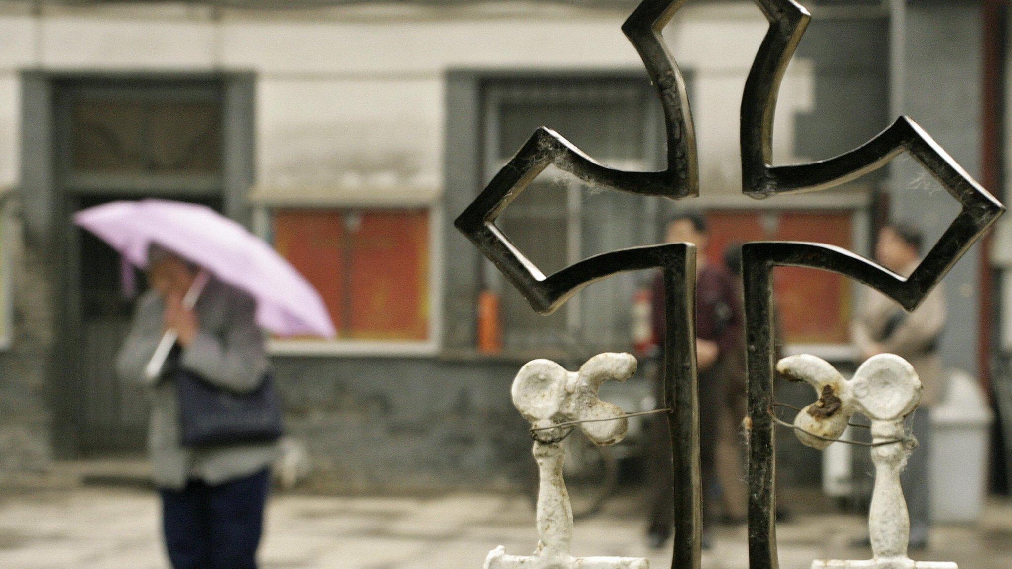 File photo: A woman prays beside a crucifix in China