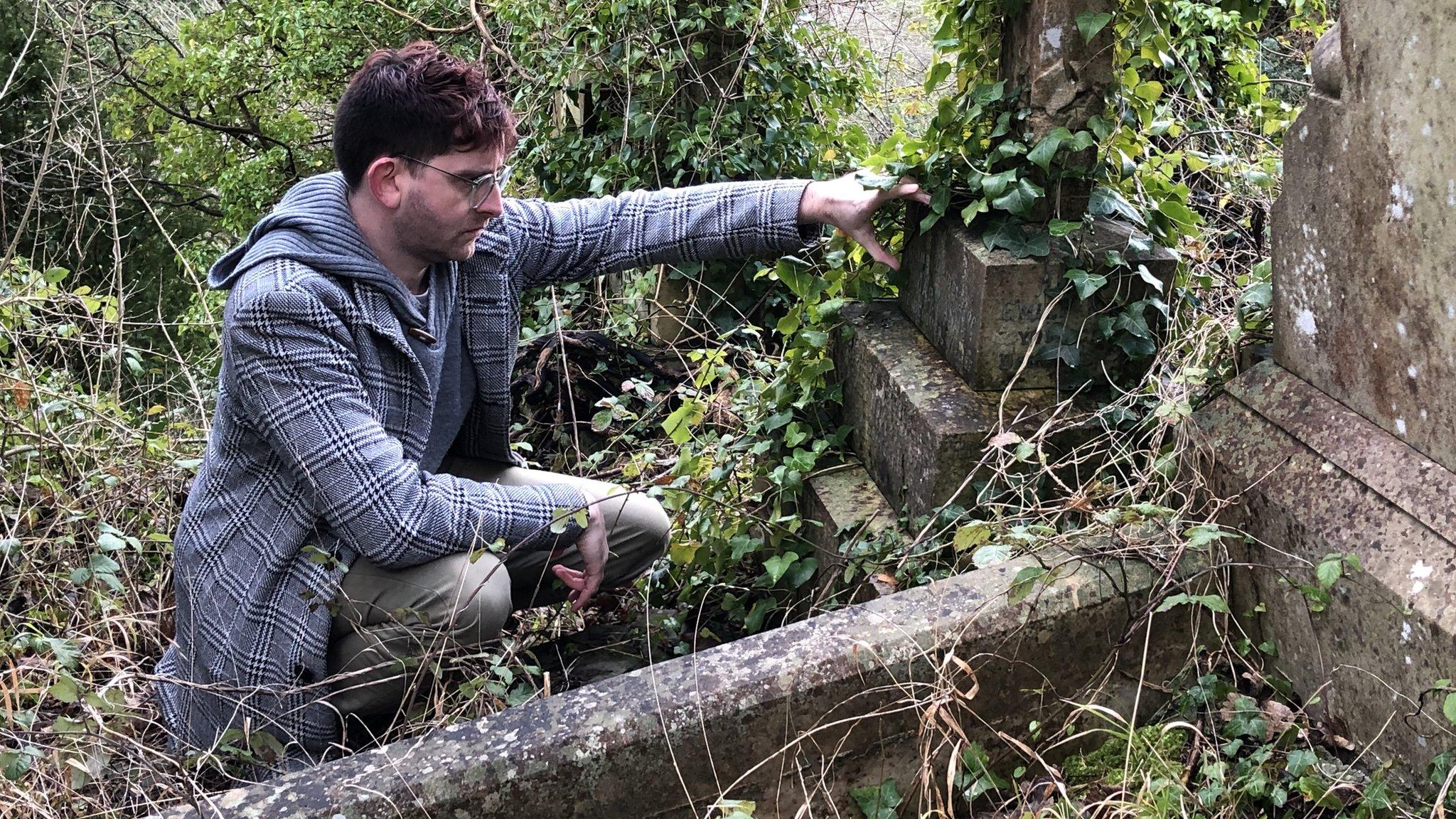 Sheldon Goodman looking at a grave