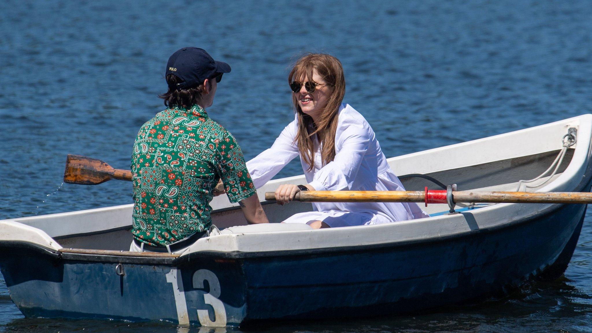 People enjoy the sun boating in Hyde Park, London