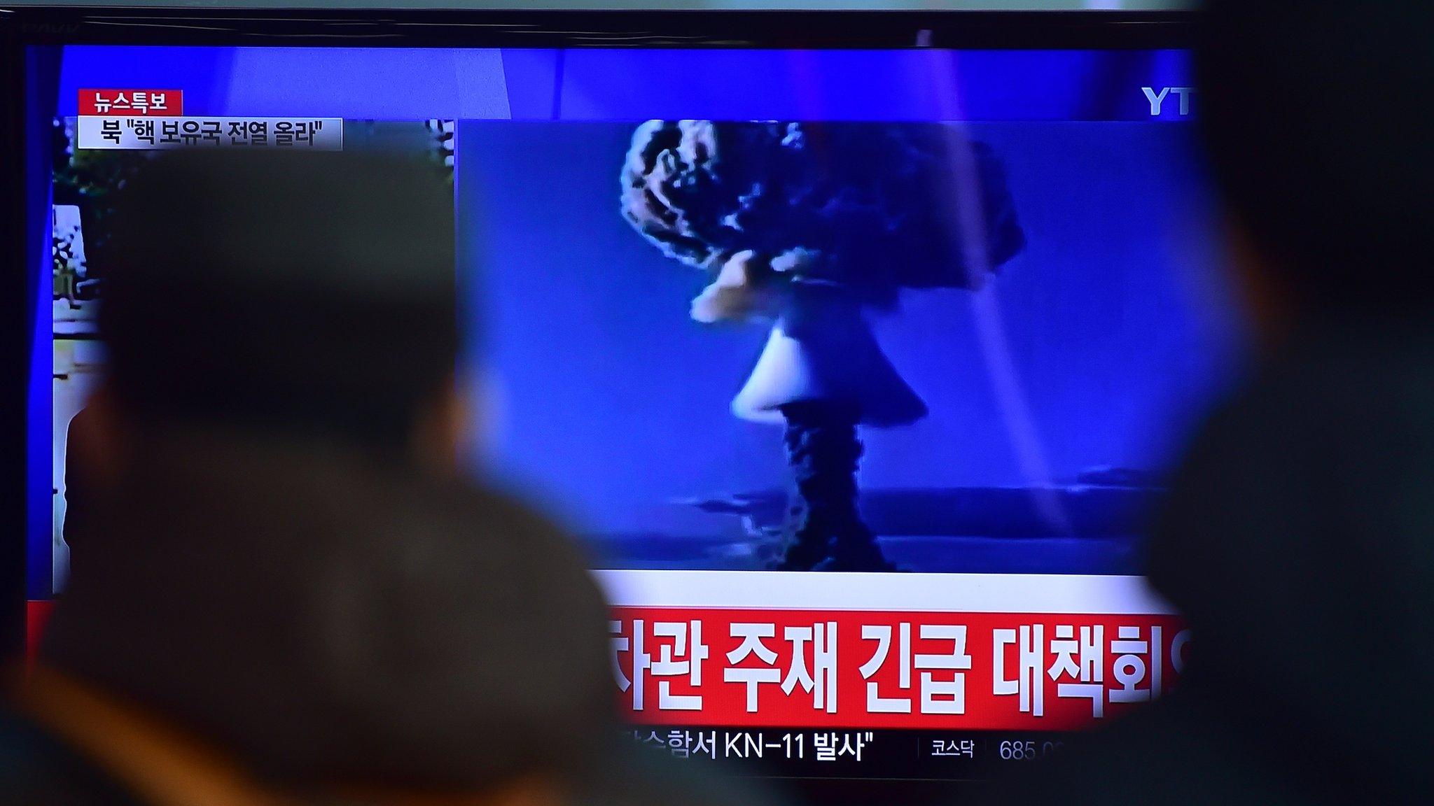 People watch a news report on North Korea's first hydrogen bomb test at a railroad station in Seoul on 6 January 2016