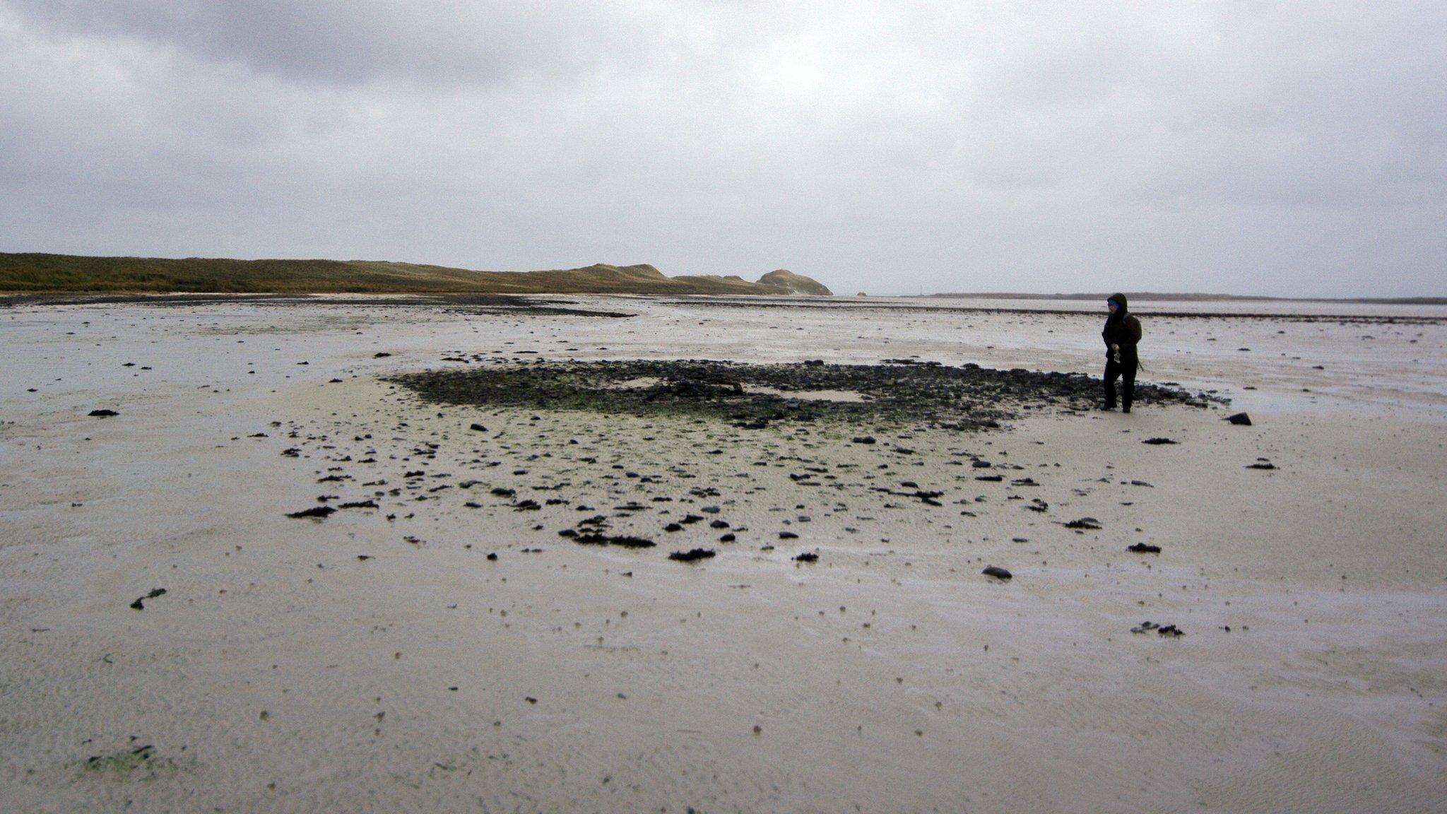 Prof Jane Downes examines one of the house structures found at Tresness