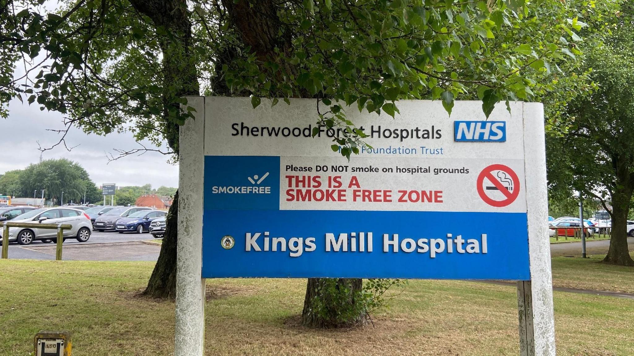 Sign for Kings Mill Hospital, with parked cars visible in the background