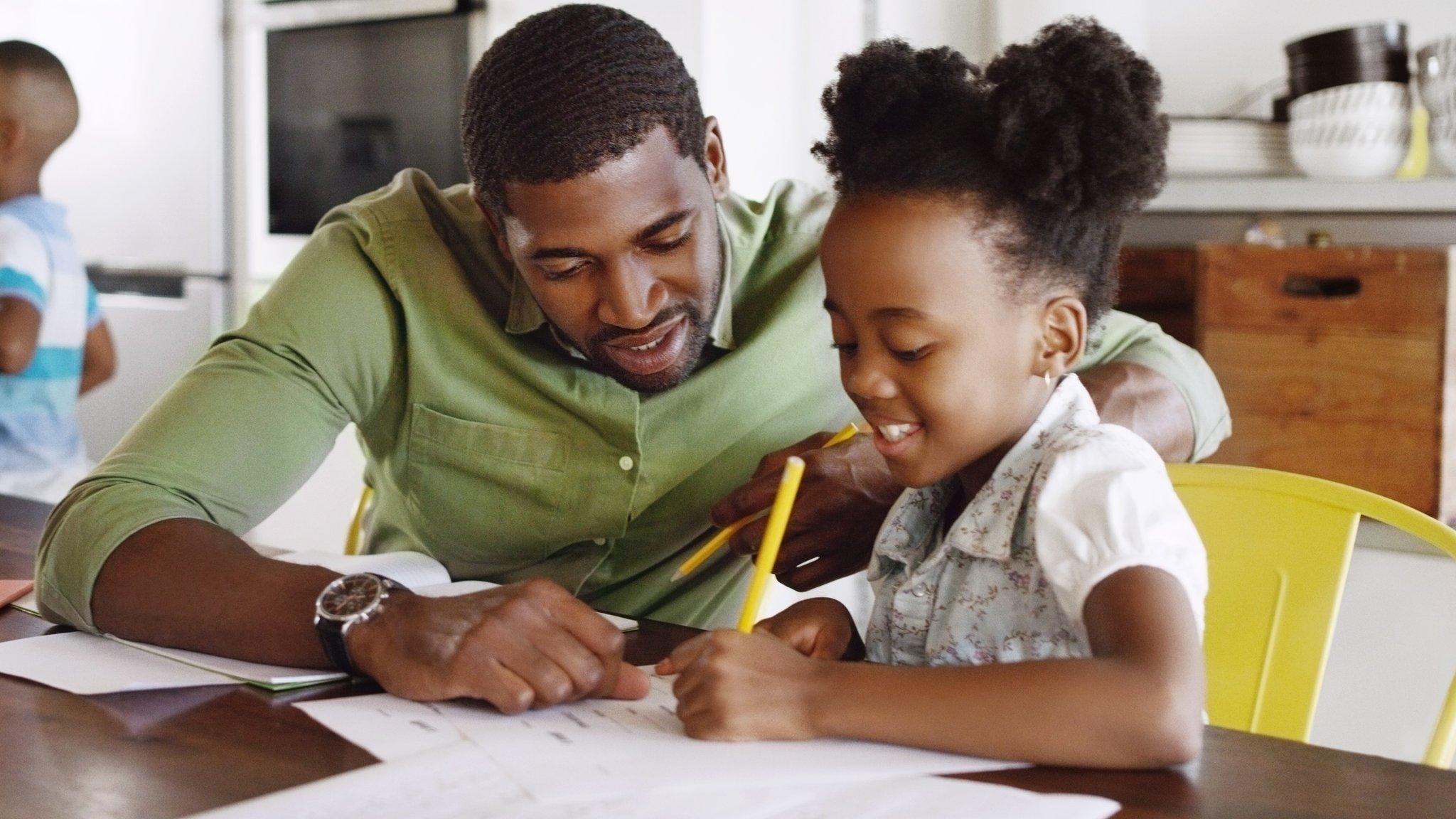 A-young-girl-doing-homework-with-her-dad