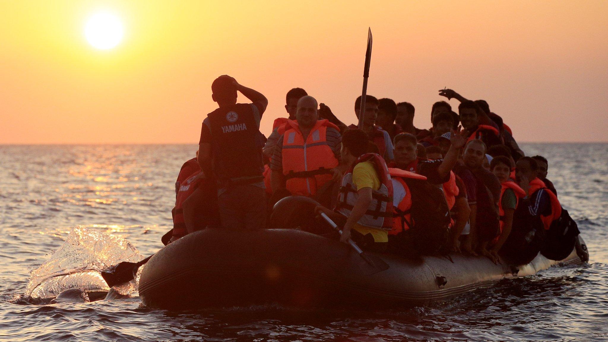 Migrants and refugees paddling a rubber dinghy close to the Greek coast