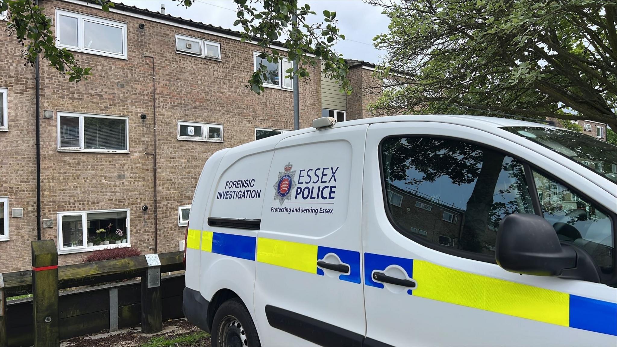 A forensic van outside the flats