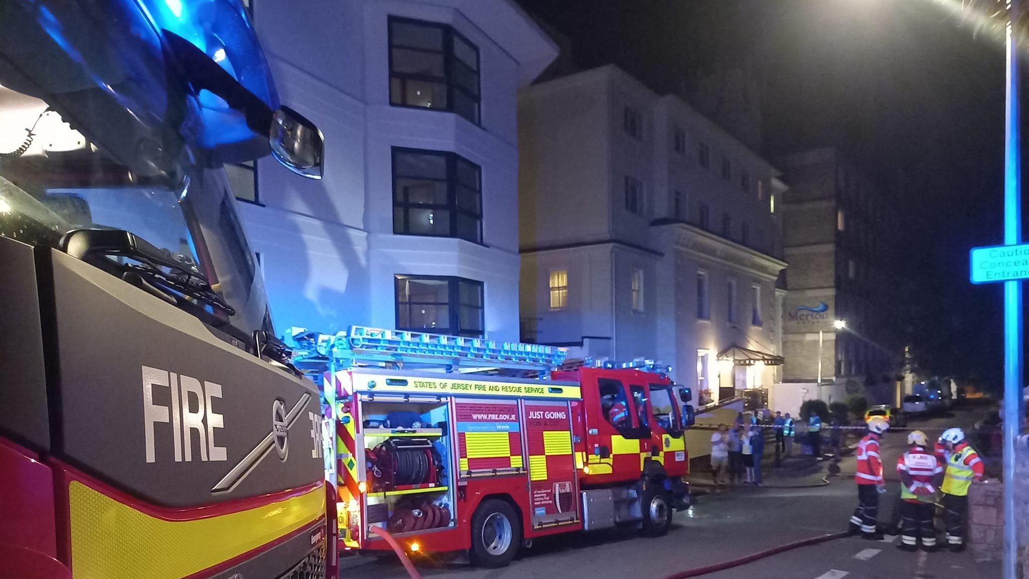 Firefighters and fire engines tackling apartment fire in Jersey