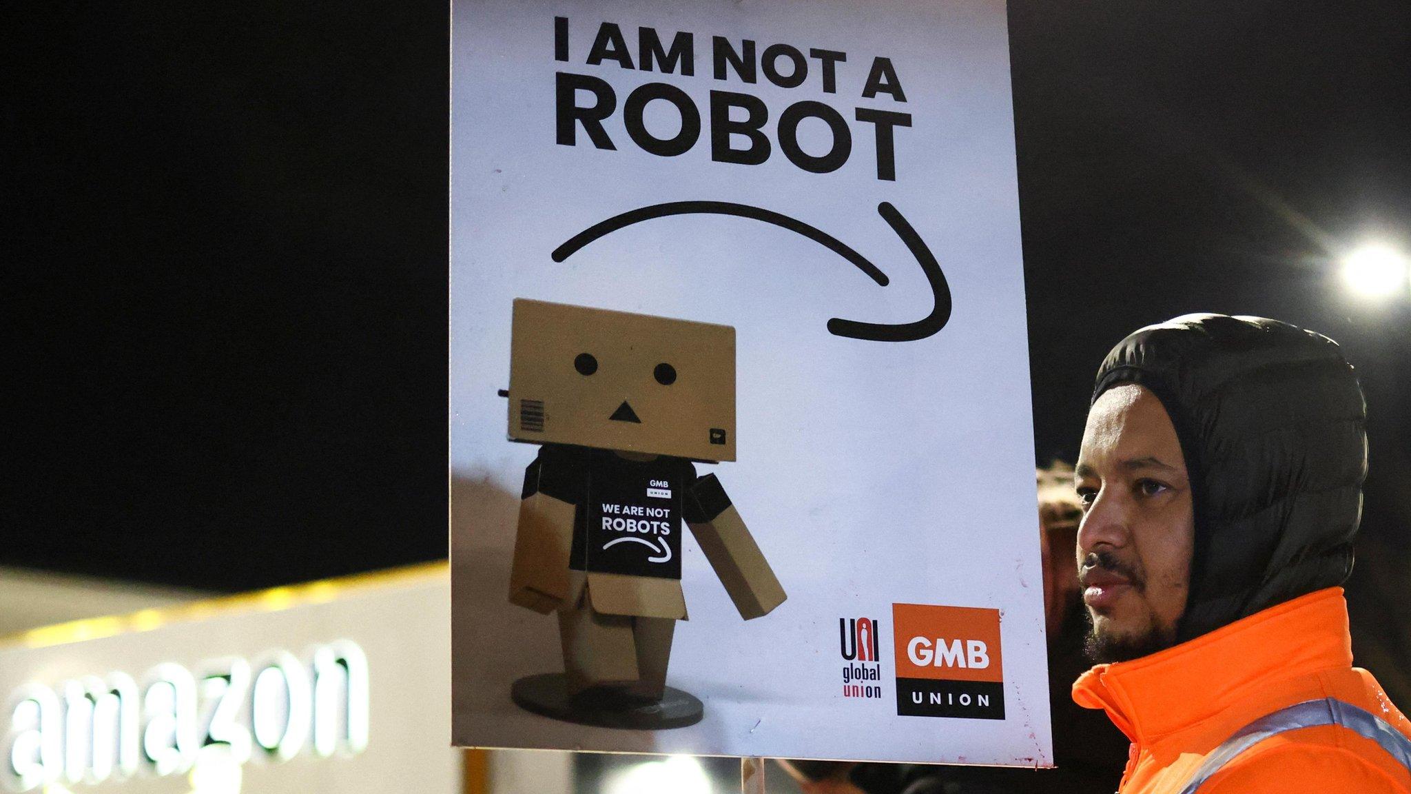 A man holds a sign during a rally in support of Amazon workers' on strike, outside the Amazon warehouse, in Coventry, Britain, January 25, 202