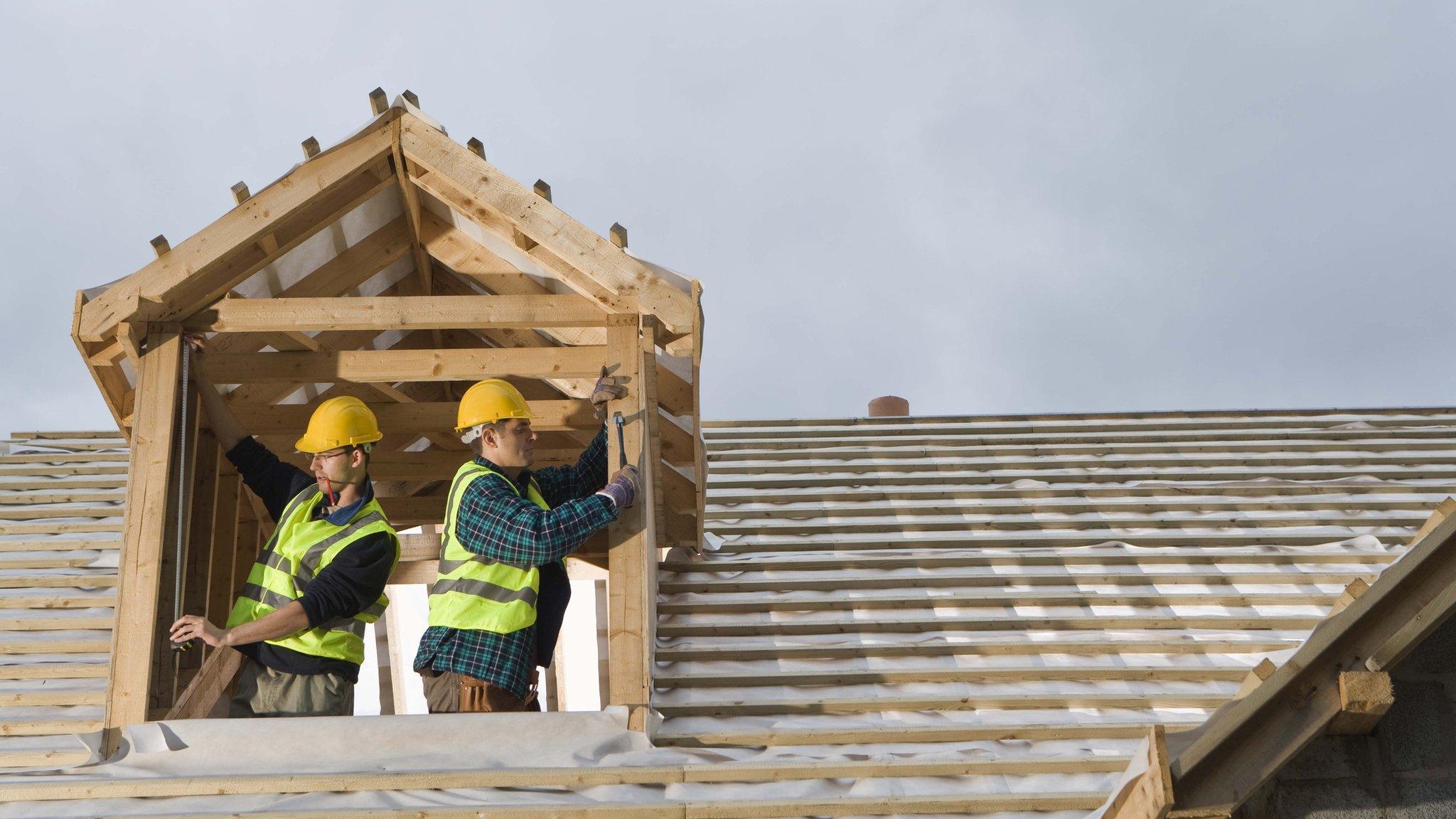 Men building a window frame on a new house