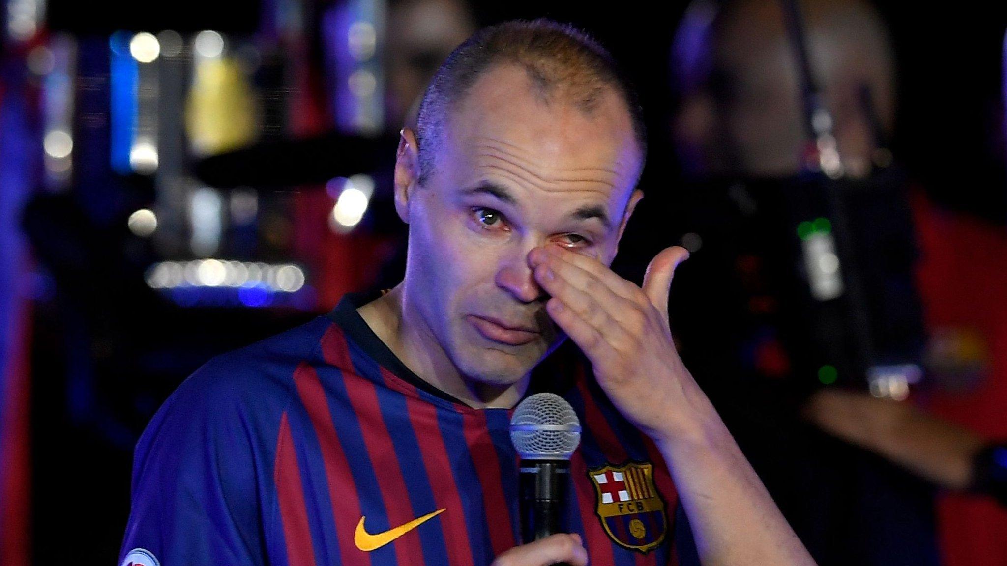 Andres Iniesta wipes away a tear as he addresses the Barcelona fans