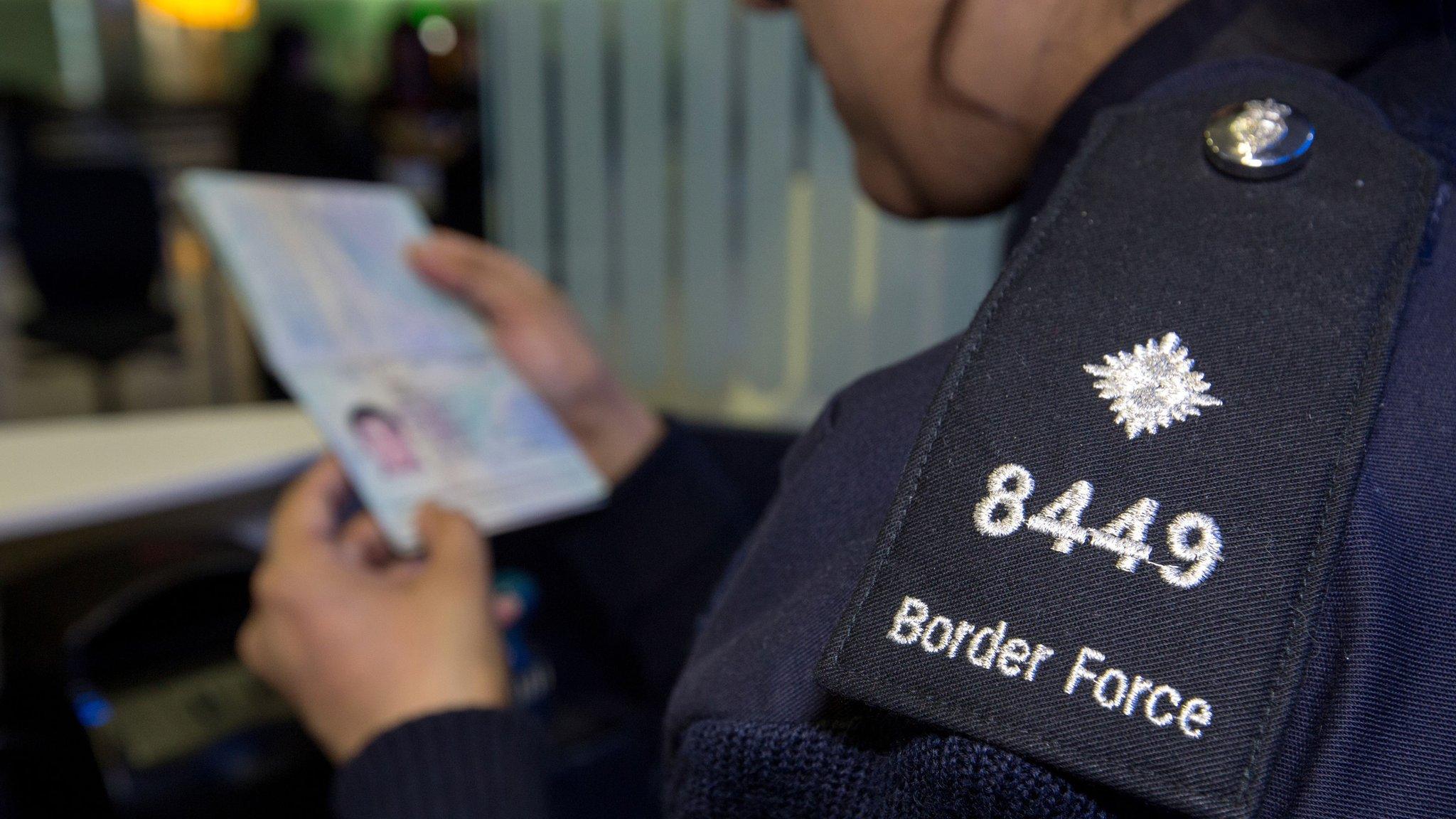 Border force officer checking passport