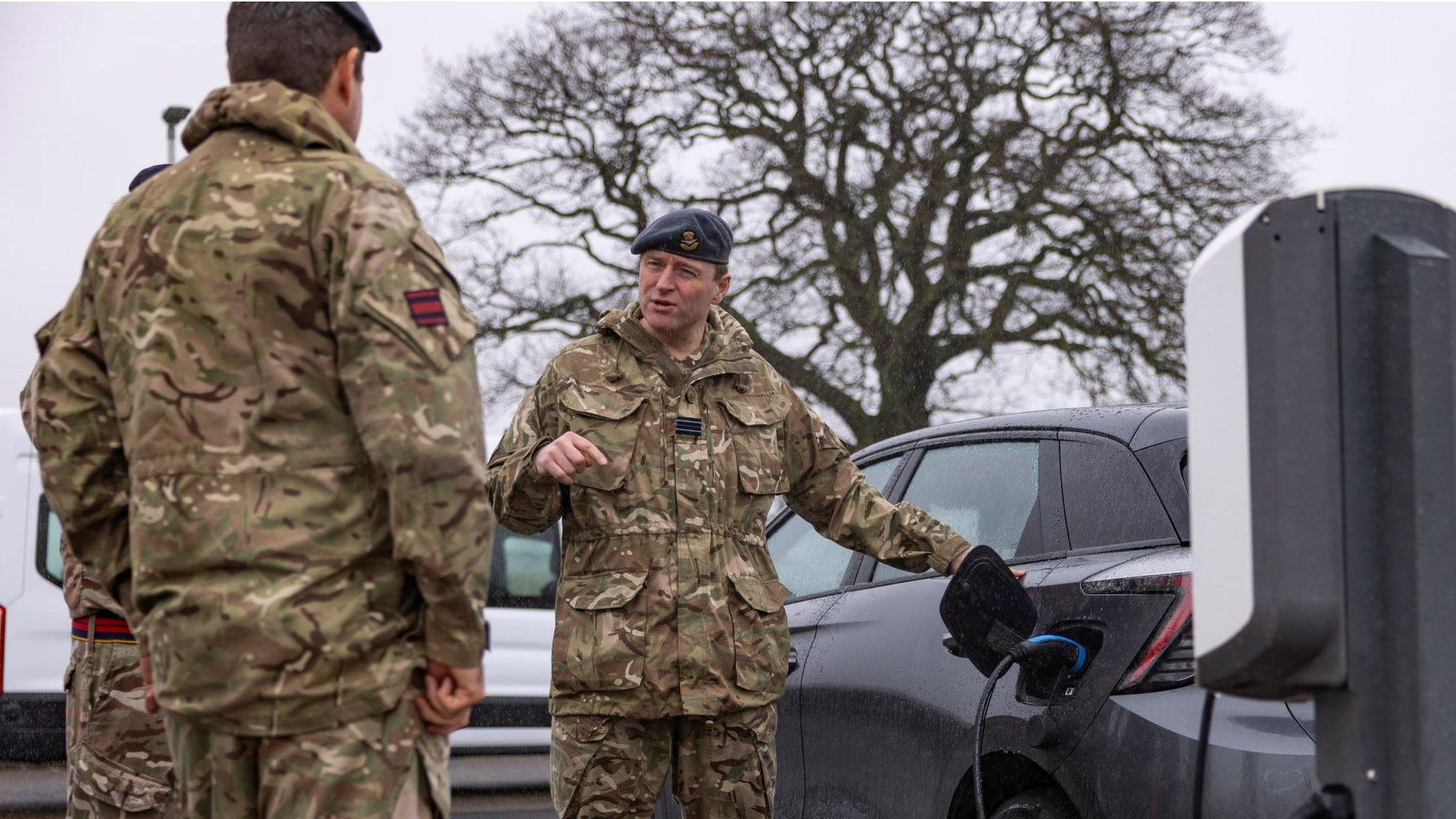 Soldier charging an electric car