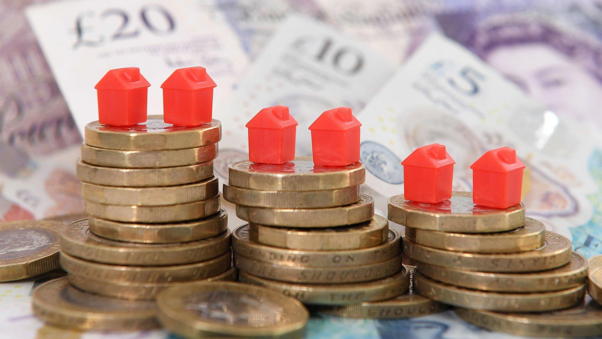 Coins and model houses on top of banknotes