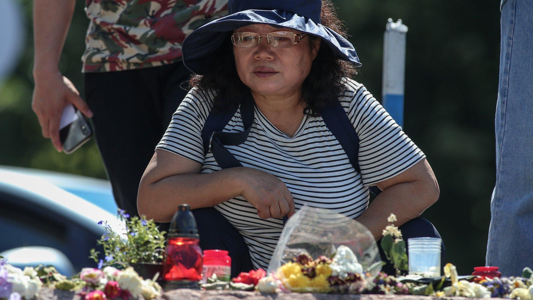 A woman looks at tributes on the banks of the river Danube