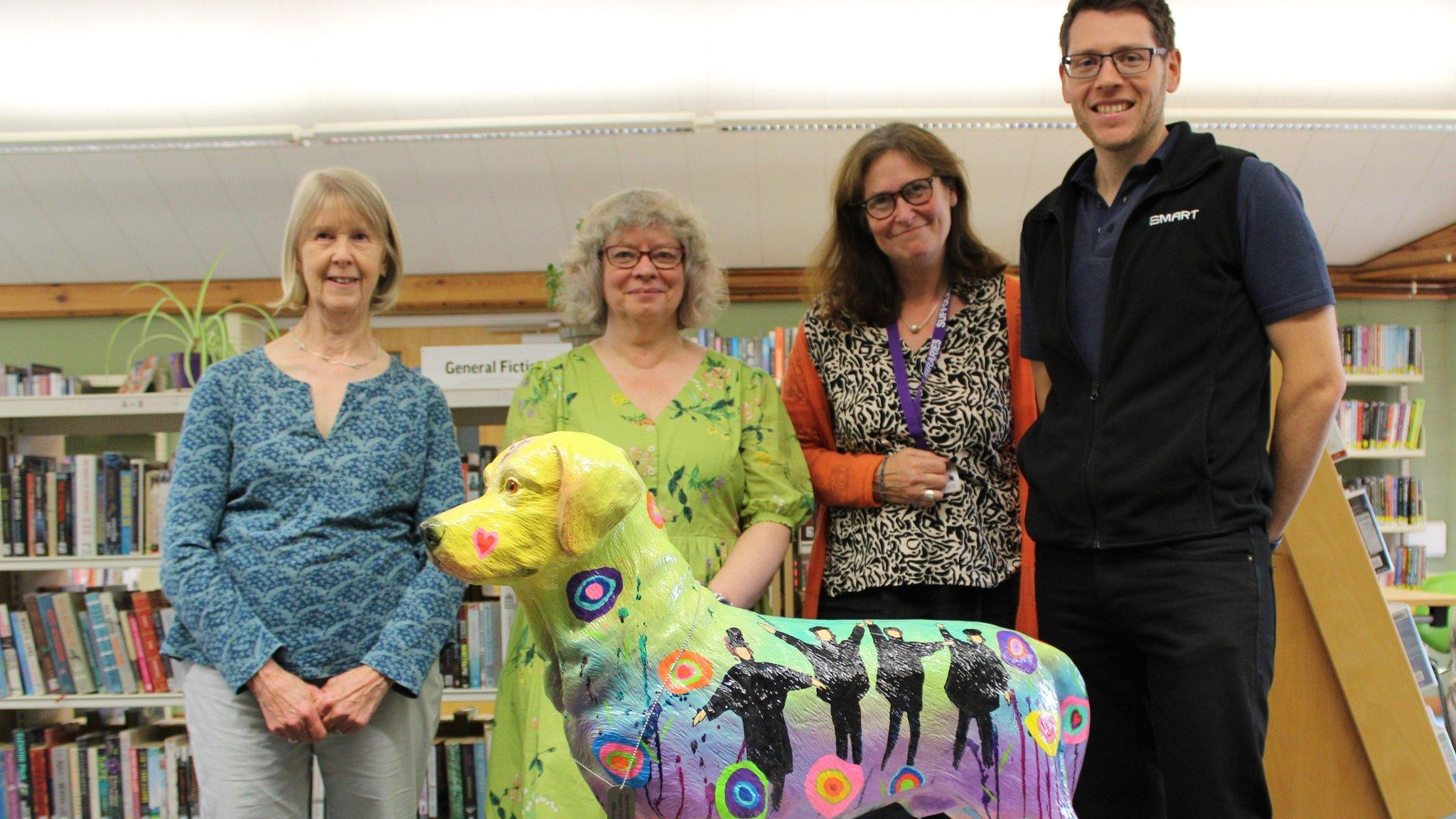 A dog sculpture inspired by The Beatles, with the artist and library workers