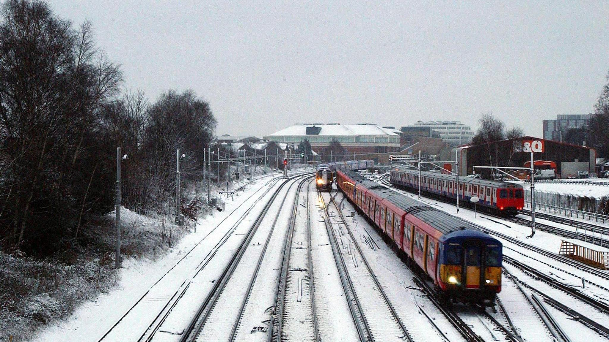 A train travels through snow covered tracks in Wimbledon