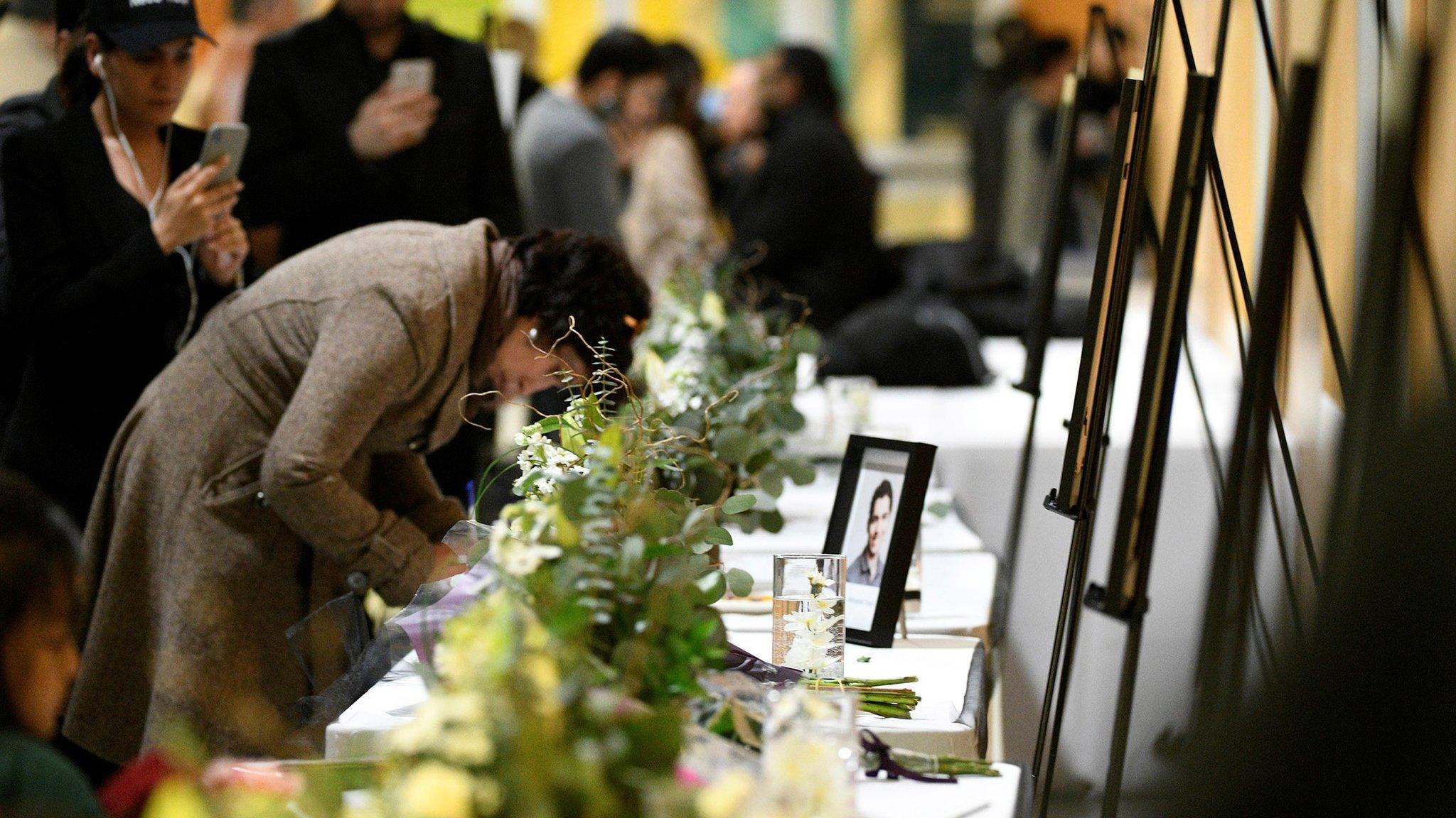 A woman writes in a memorial book at a service for victims of the plane crash in Edmonton, Canada