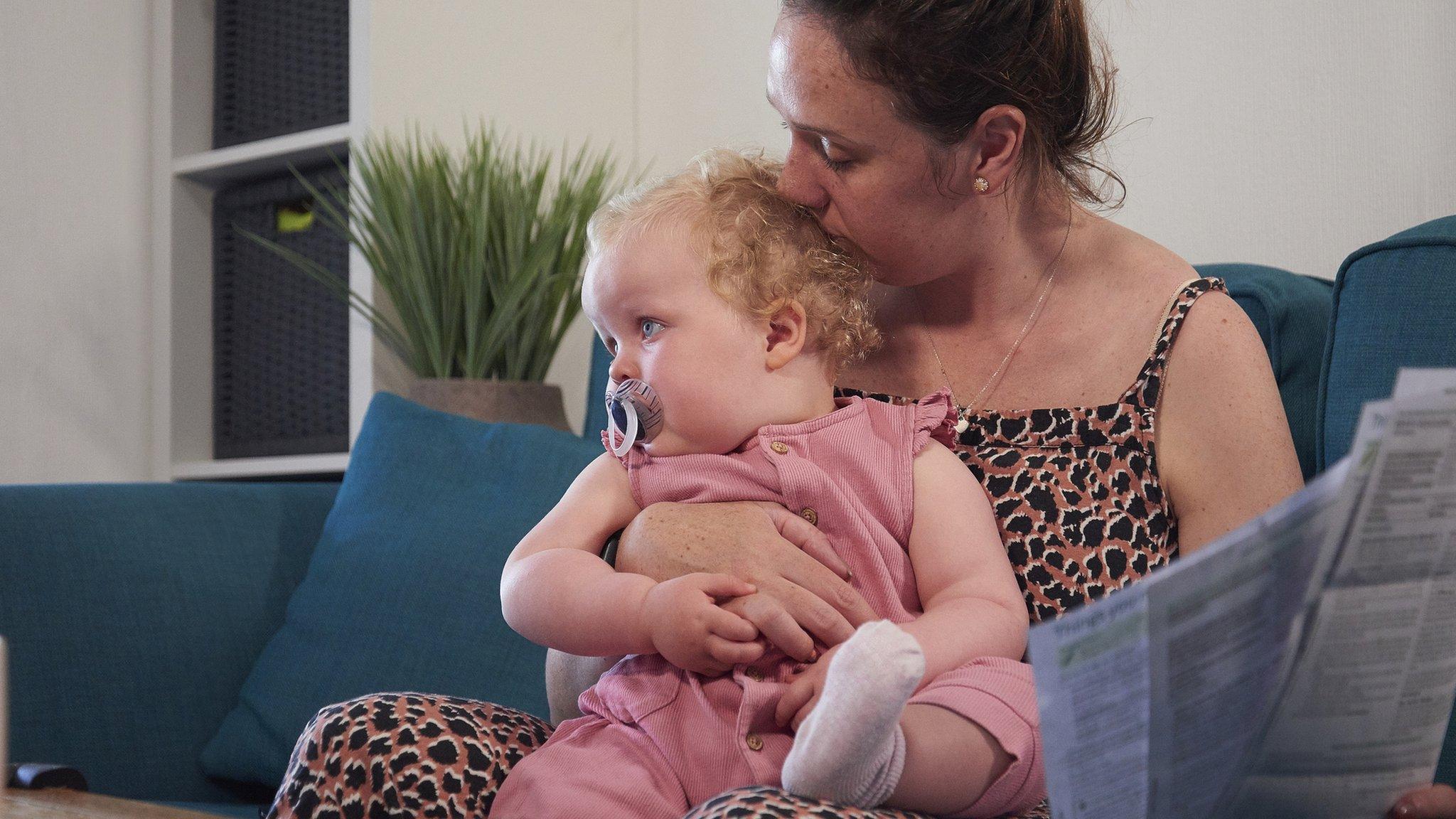 Woman with child looking concerned while reading bills