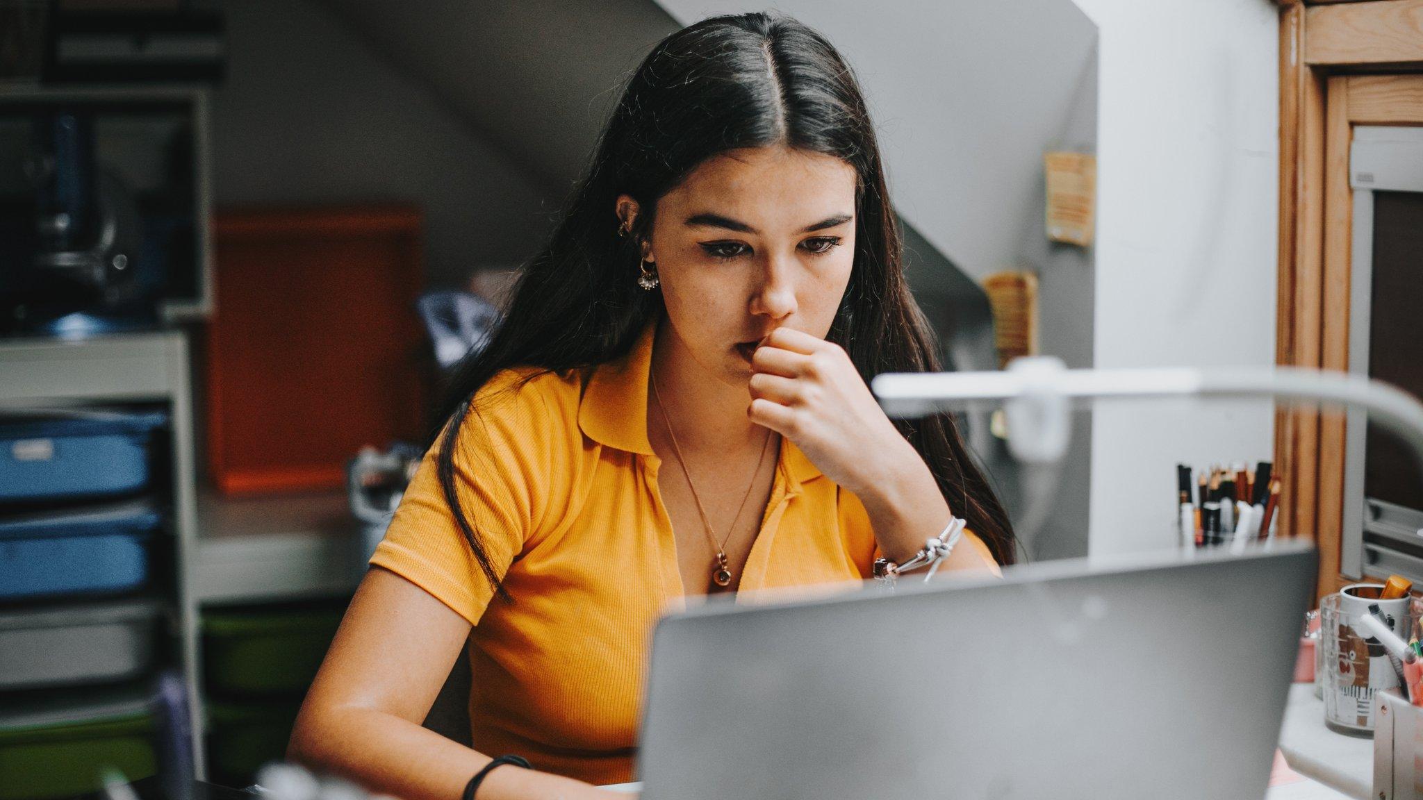 A teenager looking at her computer screen