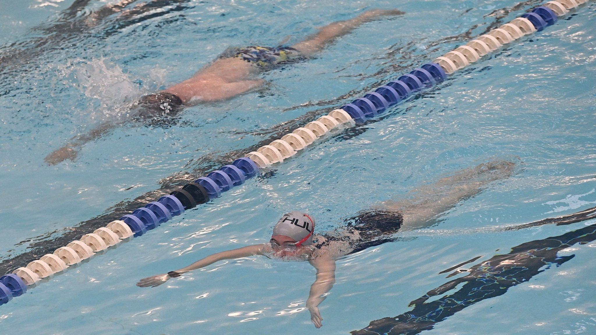 Members of the public swim in a leisure centre swimming pool