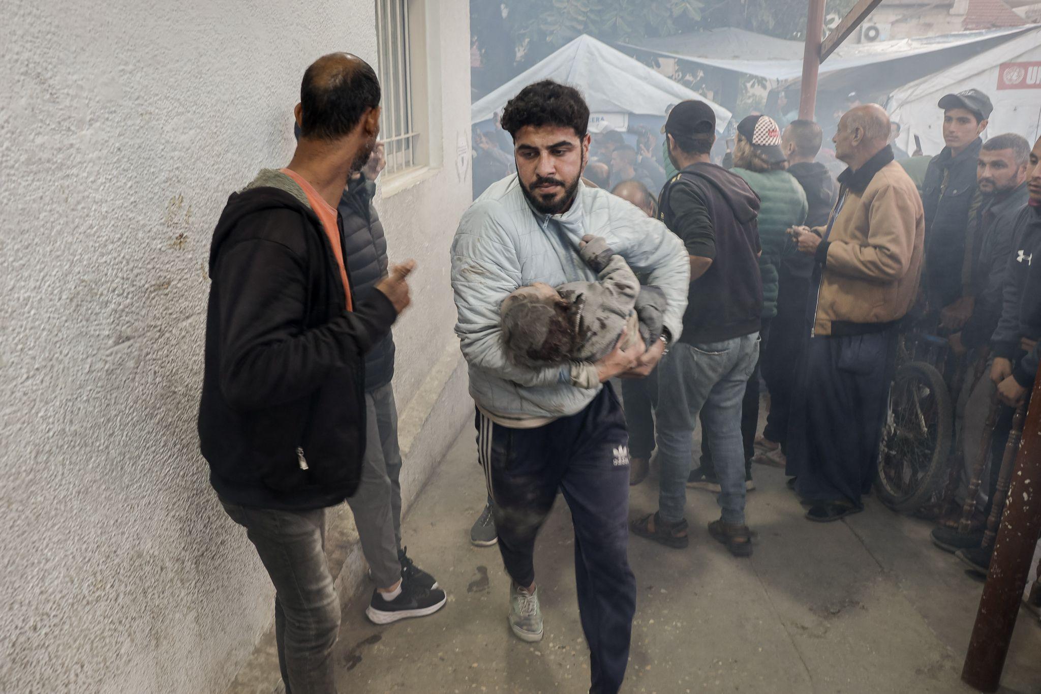 Rescue worker Nooh Al-Shagnobi rushes an injured child into the Al-Ahli Baptist Hospital in Gaza City. 