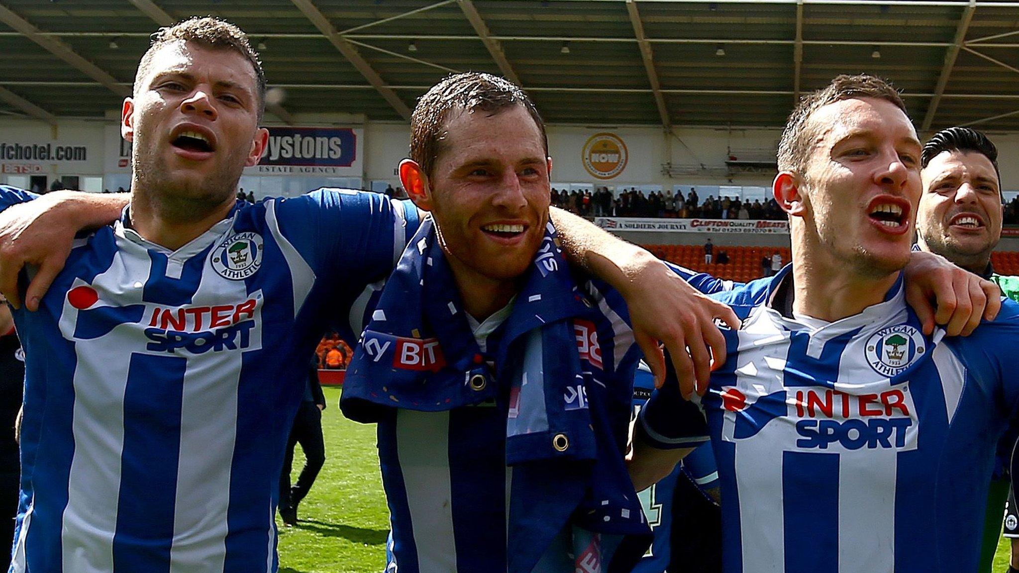 Wigan players celebrate promotion to the Championship