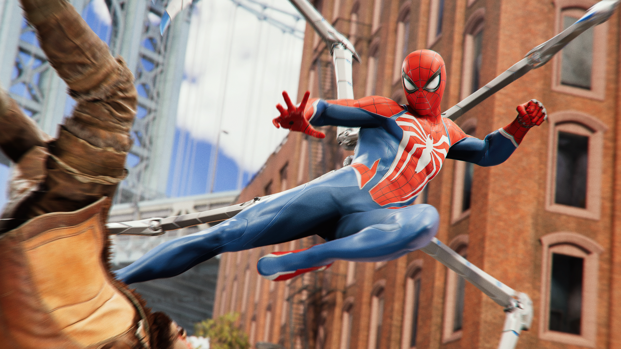 An action shot from Spider-Man 2 of the superhero flying through the air, kicking an enemy to the ground. Spider-Man has articulated spider legs emerging from his back, and the enemy, wearing a light brown jacket with dark brown arms, has his arms up over his head as he falls to the ground.