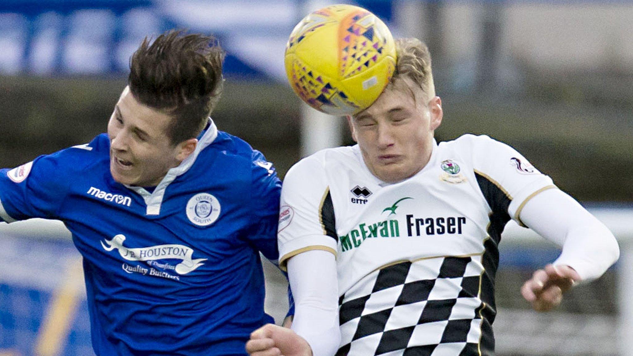 Lyndon Dykes of Queen of the South and Inverness CT's Coll Donaldson contest possession