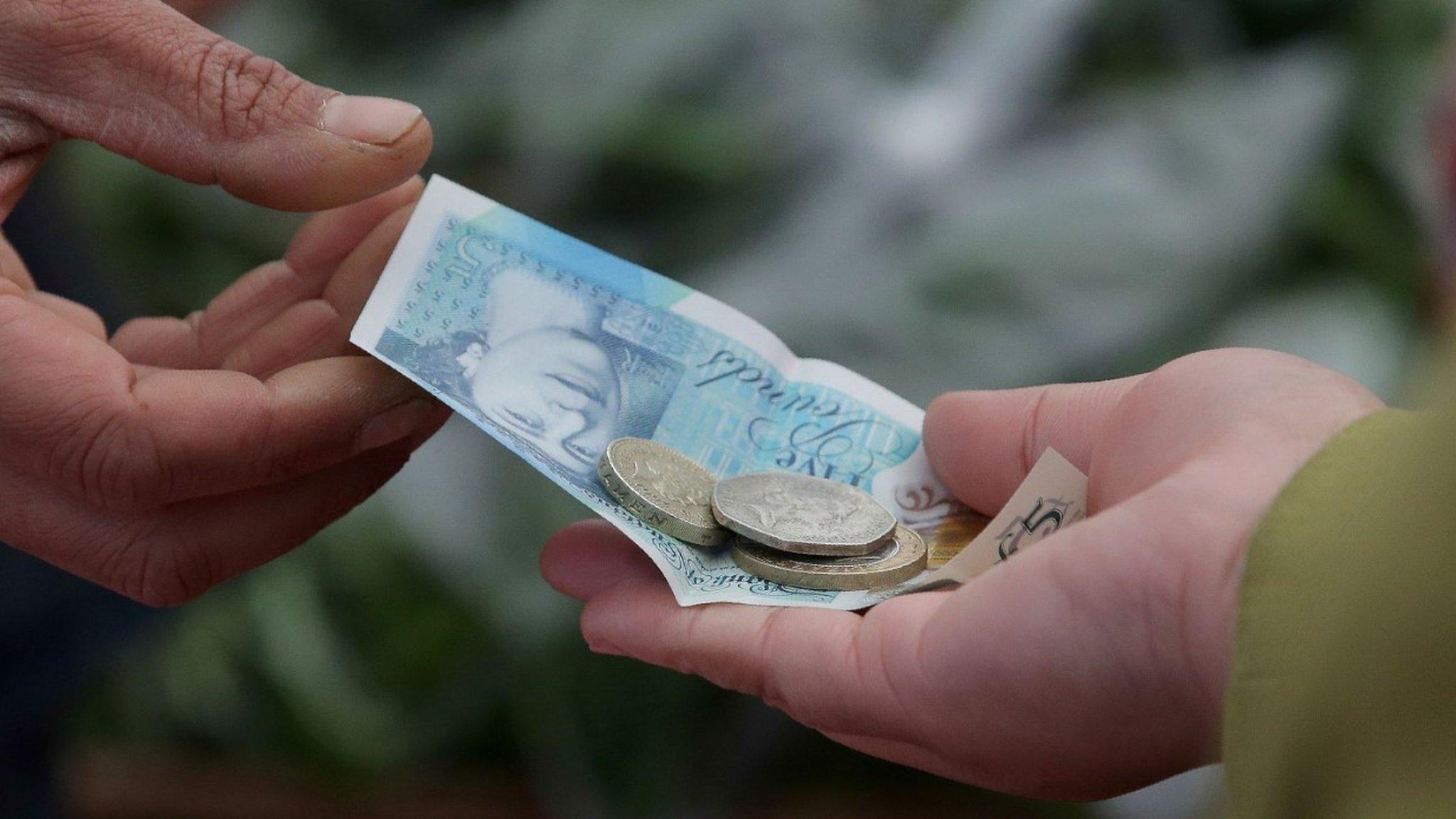 People holding sterling notes and coins