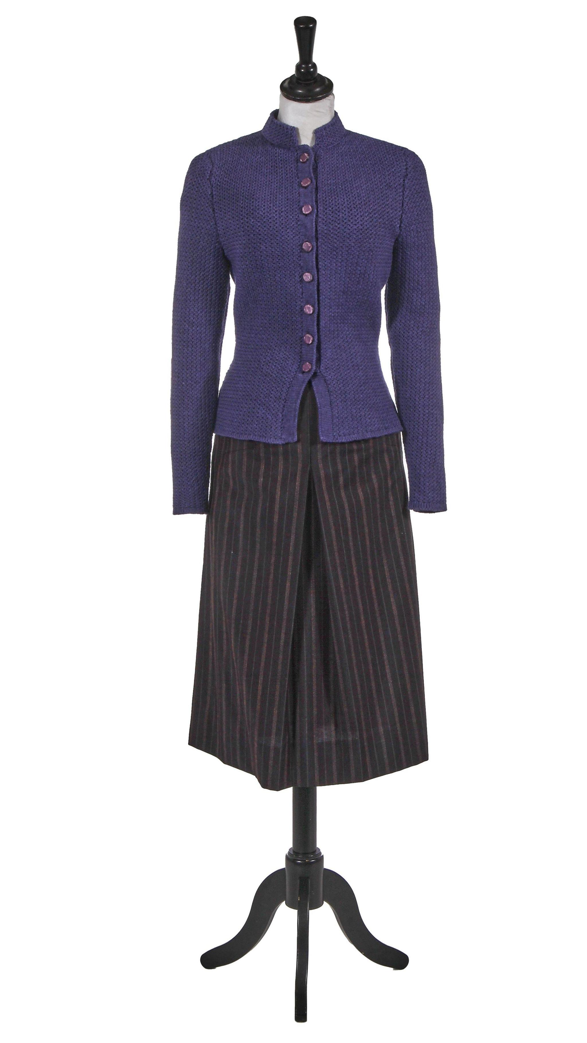 A 1940s style ensemble comprising a deep purple knitted wool cardigan with a stand collar and a row of moulded buttons and a dark brown wool skirt with blue and orange pinstripes and deep pockets.