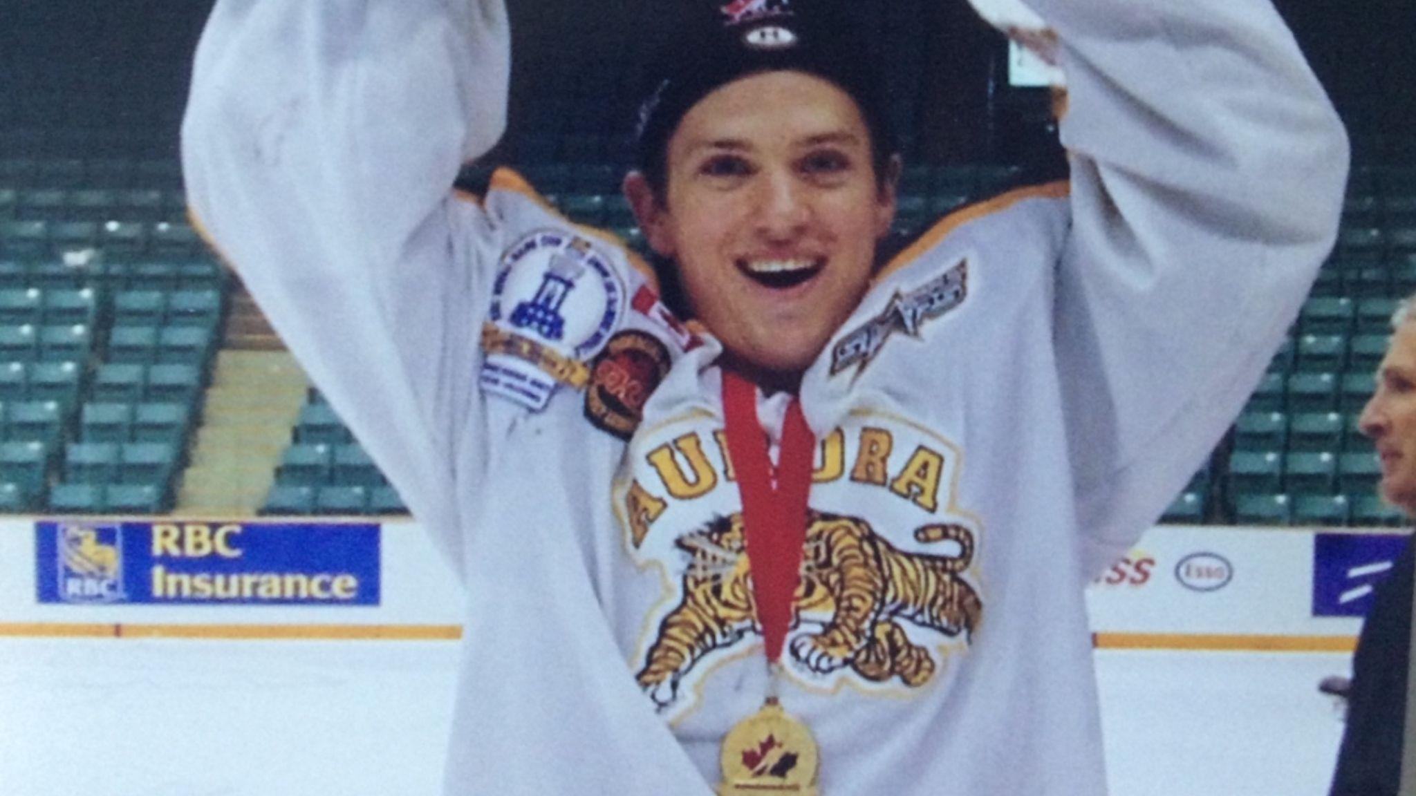 Joey Martin celebrates with a medal as he holds a trophy aloft