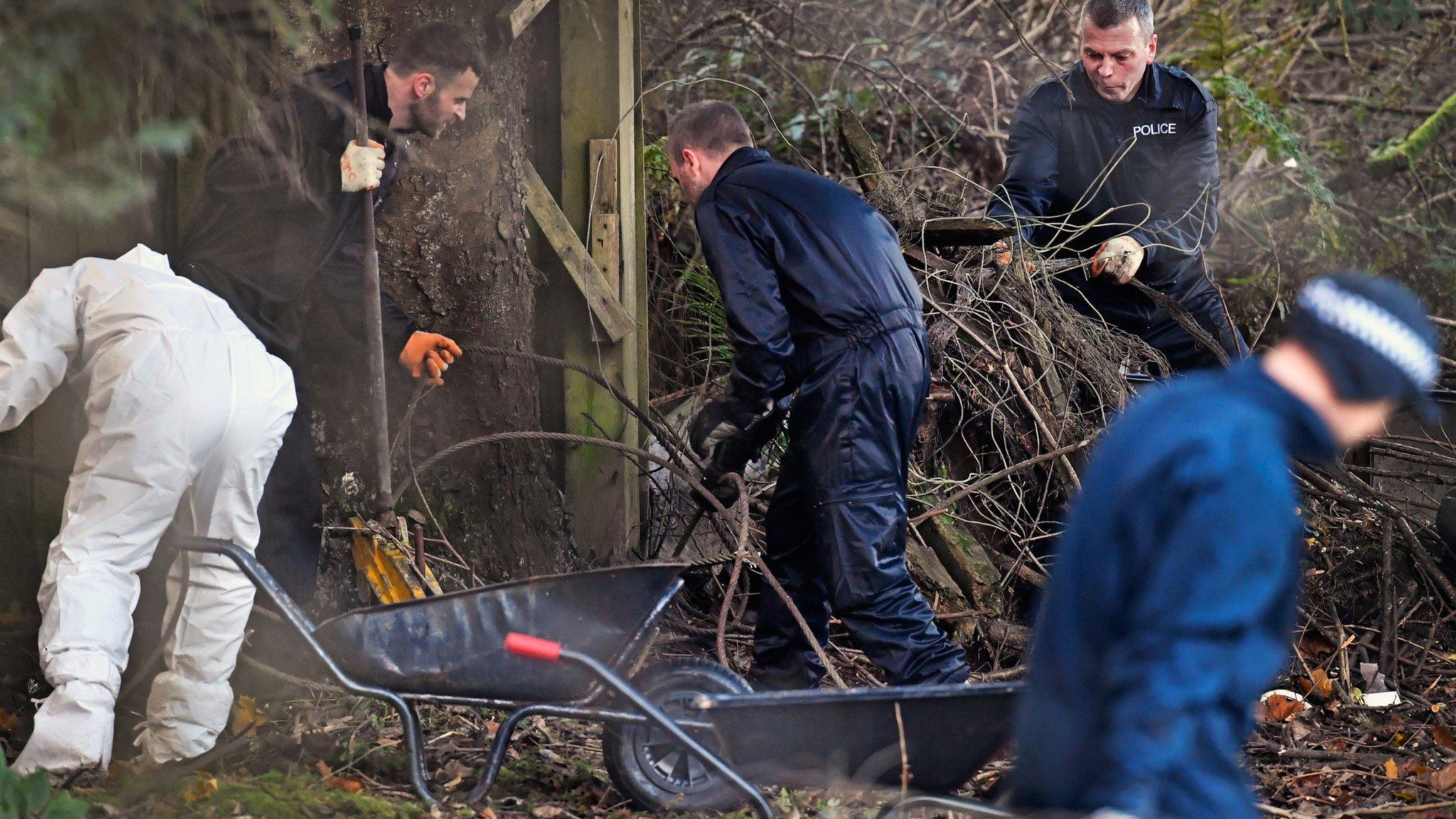 Police search the grounds of the house where Ms Fleming lived