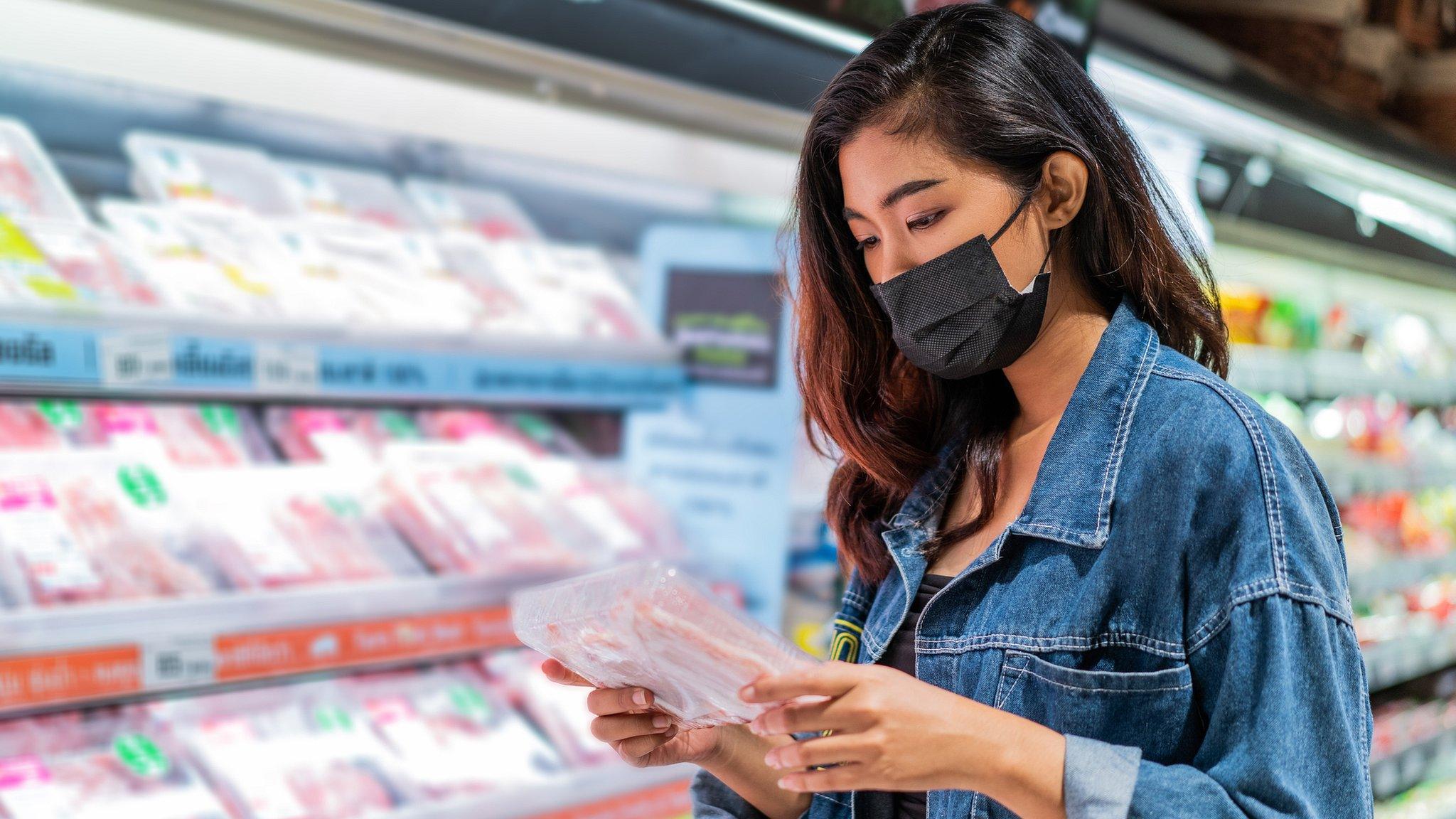 Woman buys meat in supermarket