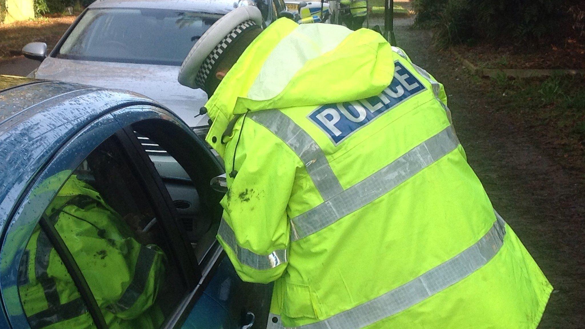 police man looks into car