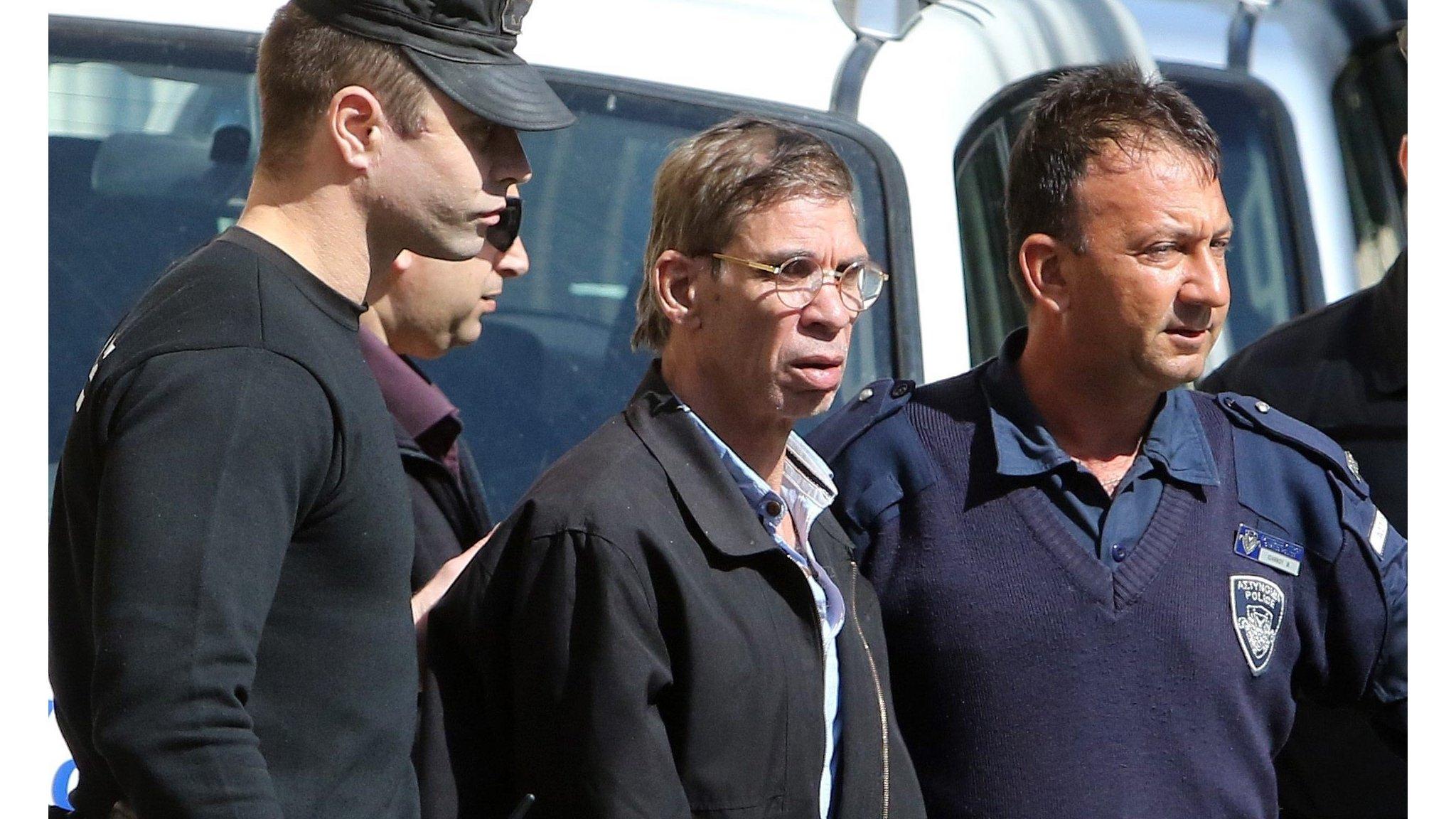 Seif Eldin Mustafa (C) flanked by Cypriot police as they leave a court in Larnaca.