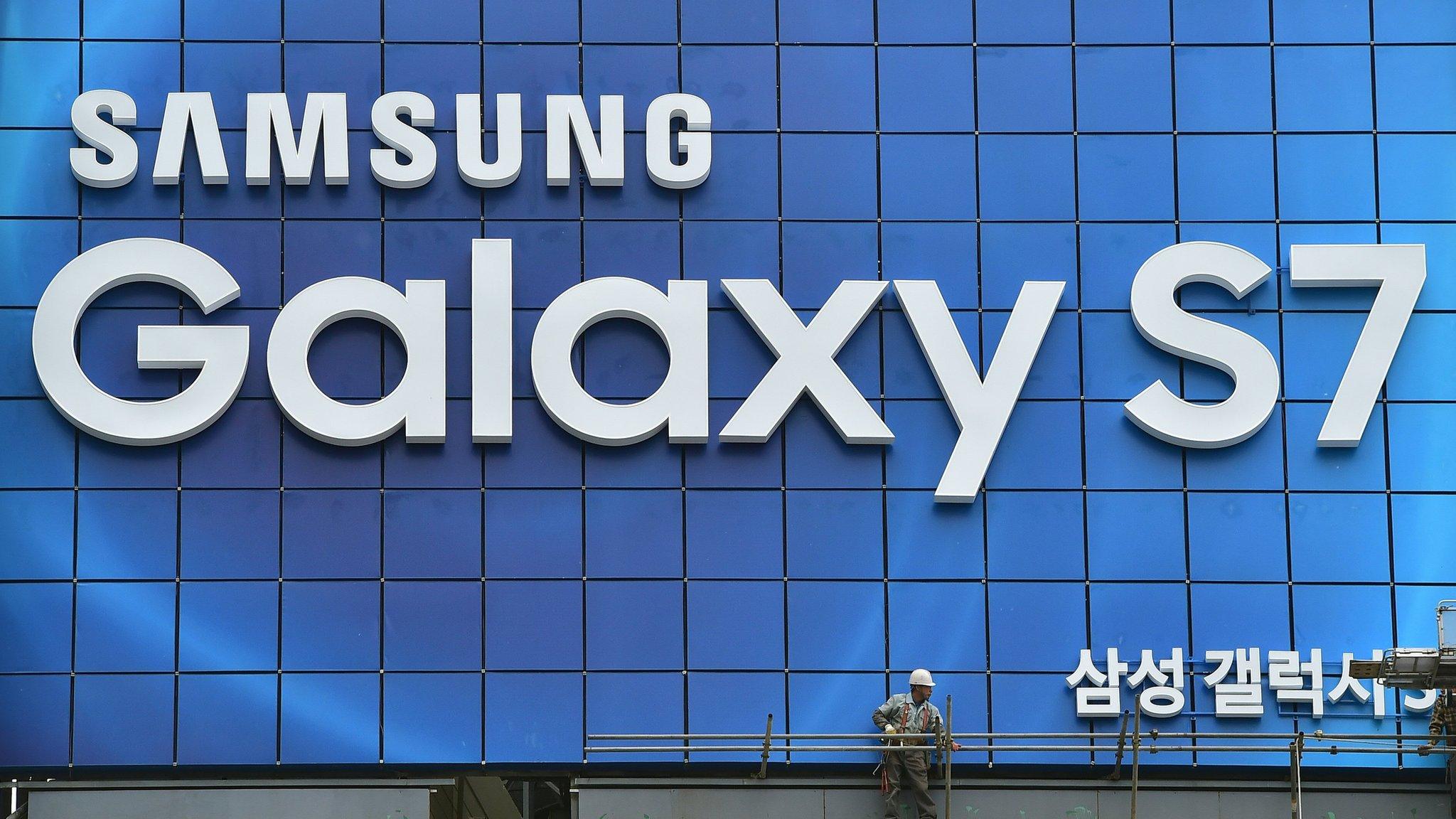 A South Korean worker removes scaffolding after setting up an advertisement billboard for Samsung's Galaxy S7 smartphone installed on top of a building in central Seoul