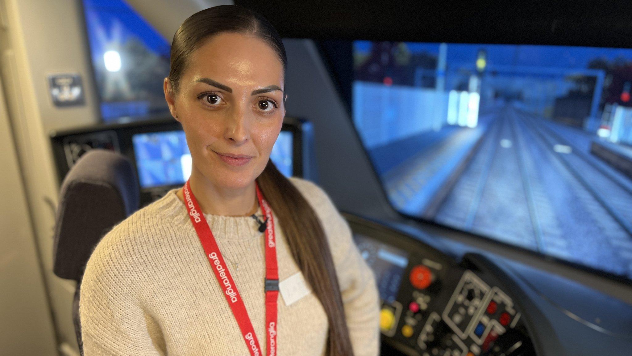 Lottie Hart, a train depot driver who works for Greater Anglia, standing inside a training simulator.