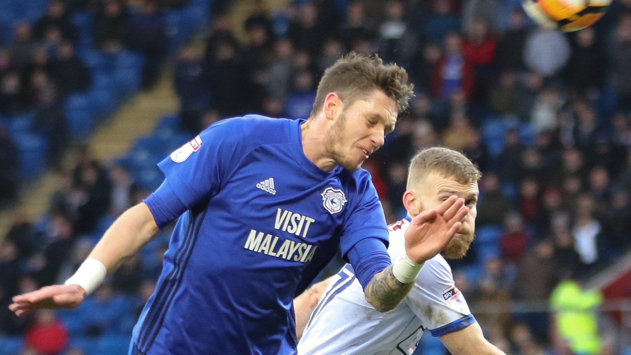 Greg Halford of Cardiff City and Alfie Potter of Mansfield Town compete for the ball