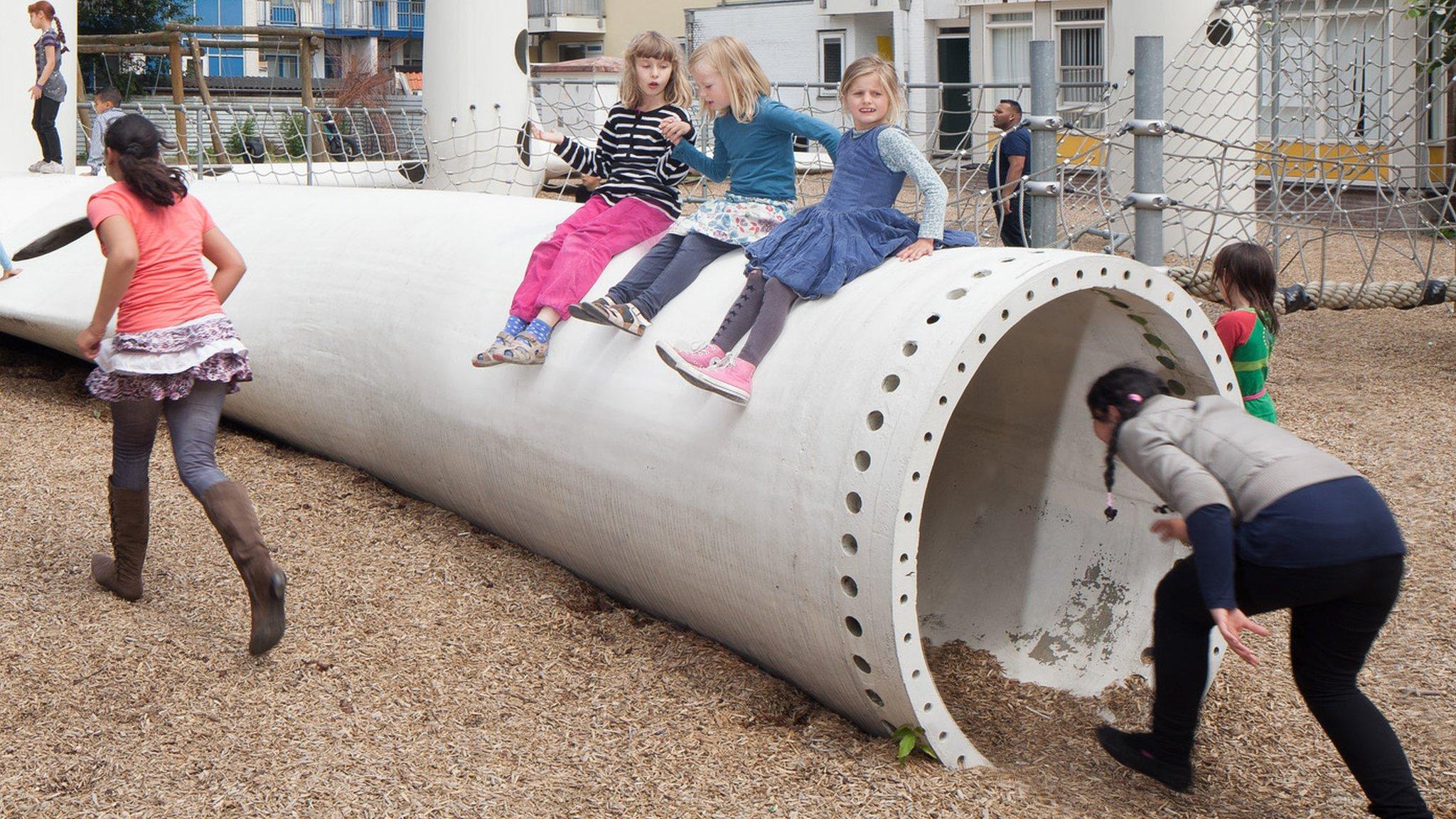 Childen in a playground made of old turbine blades