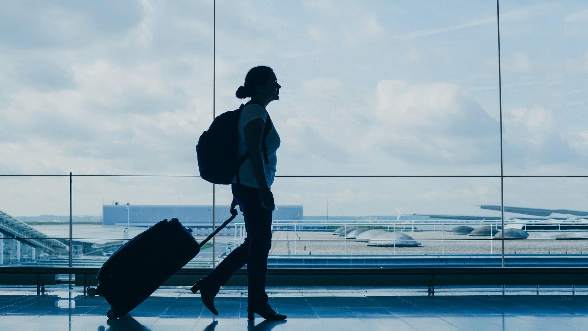 woman air traveller walking with suitcase