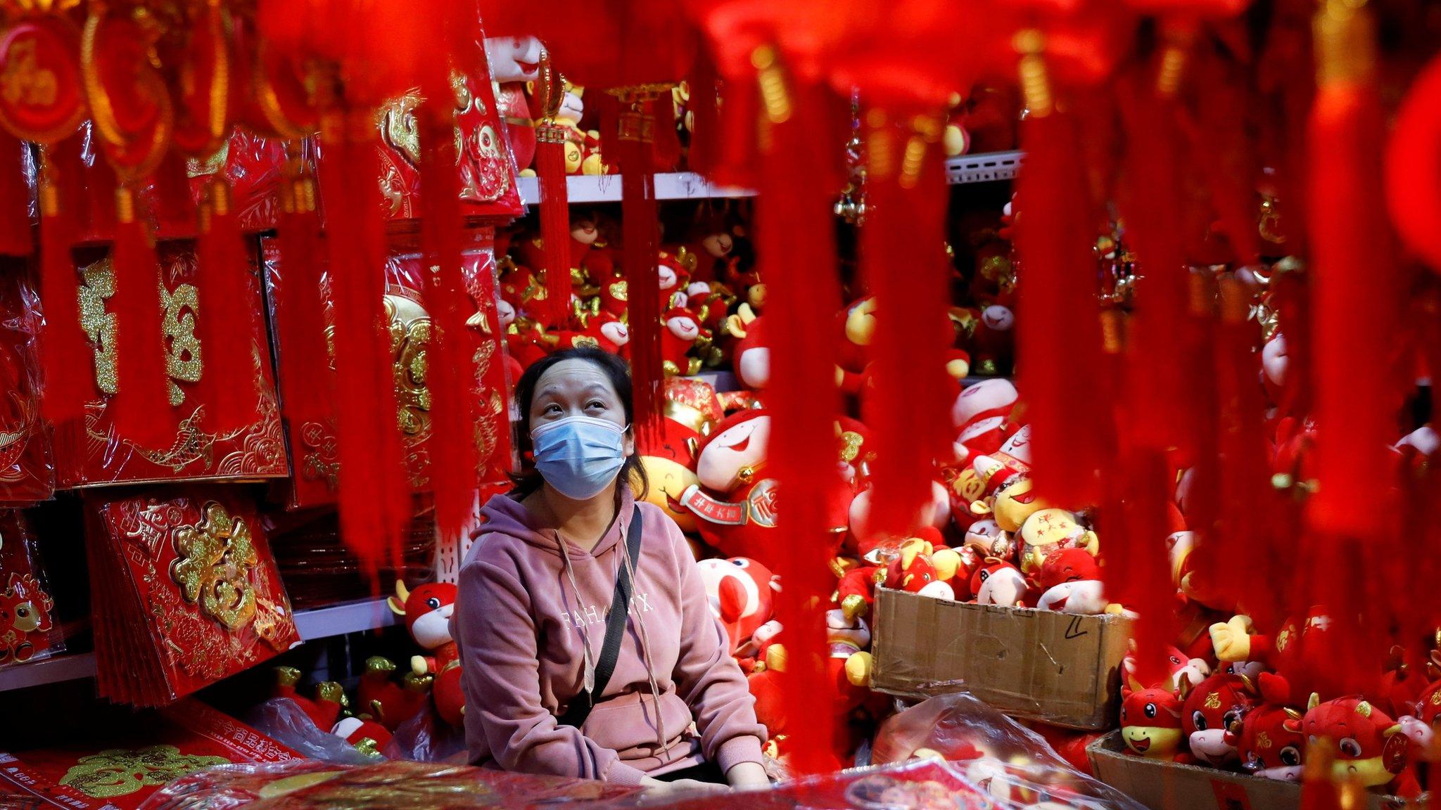 A vendor wearing a face mask following the coronavirus disease (COVID-19) outbreak waits for customers at a market selling Spring Festival ornaments ahead of the Chinese Lunar New Year festivity, in Beijing, China January 27, 2021