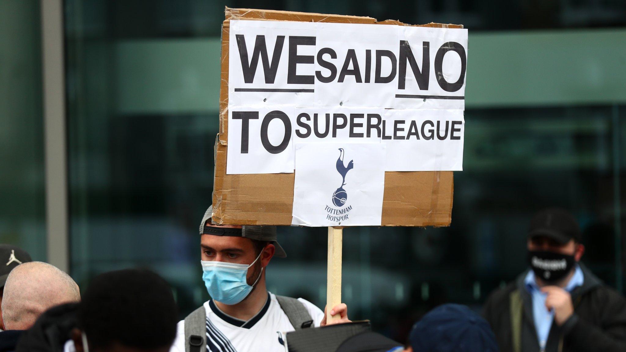 Fan holding banner against European Super League