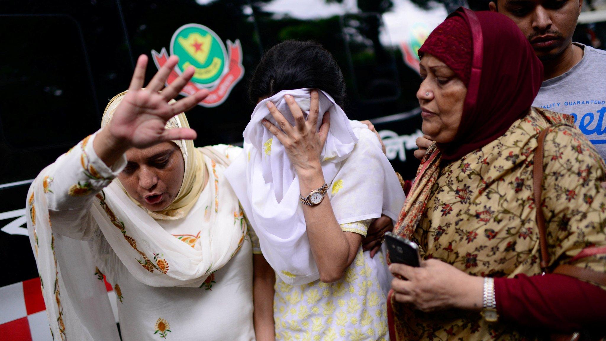 A relative tries to console a relative after militants took hostages in a restaurant popular with foreigners in Dhaka, Bangladesh, Saturday, July 2, 2016