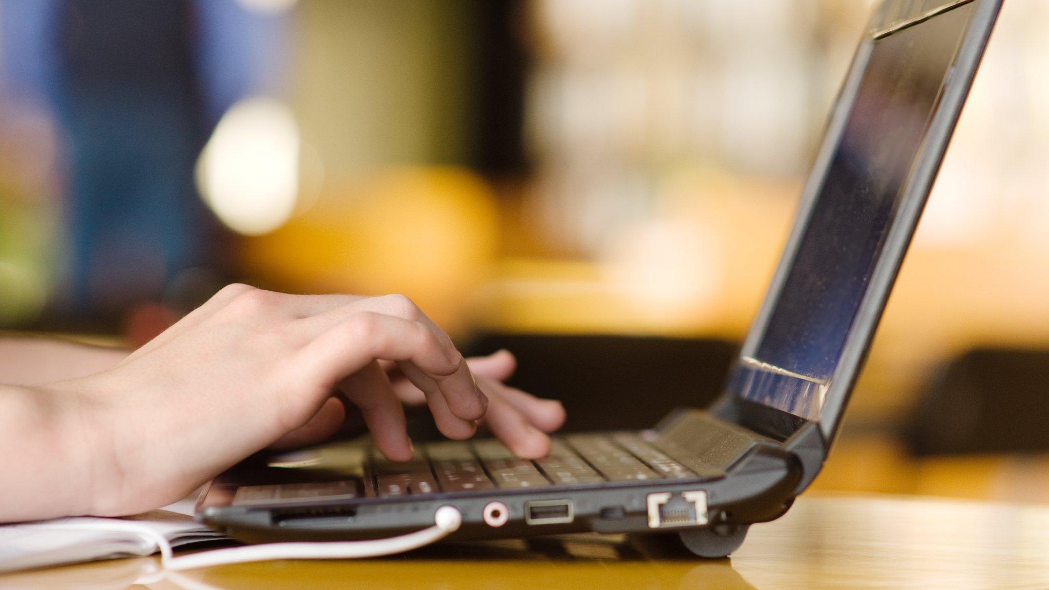 Hands using a laptop computer