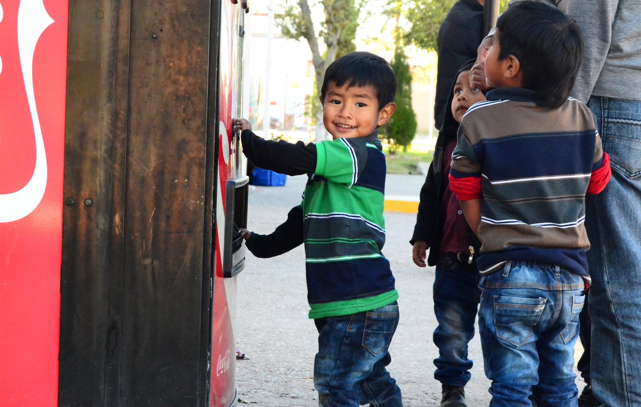 Rogerio's son playing at Coca-Cola machine